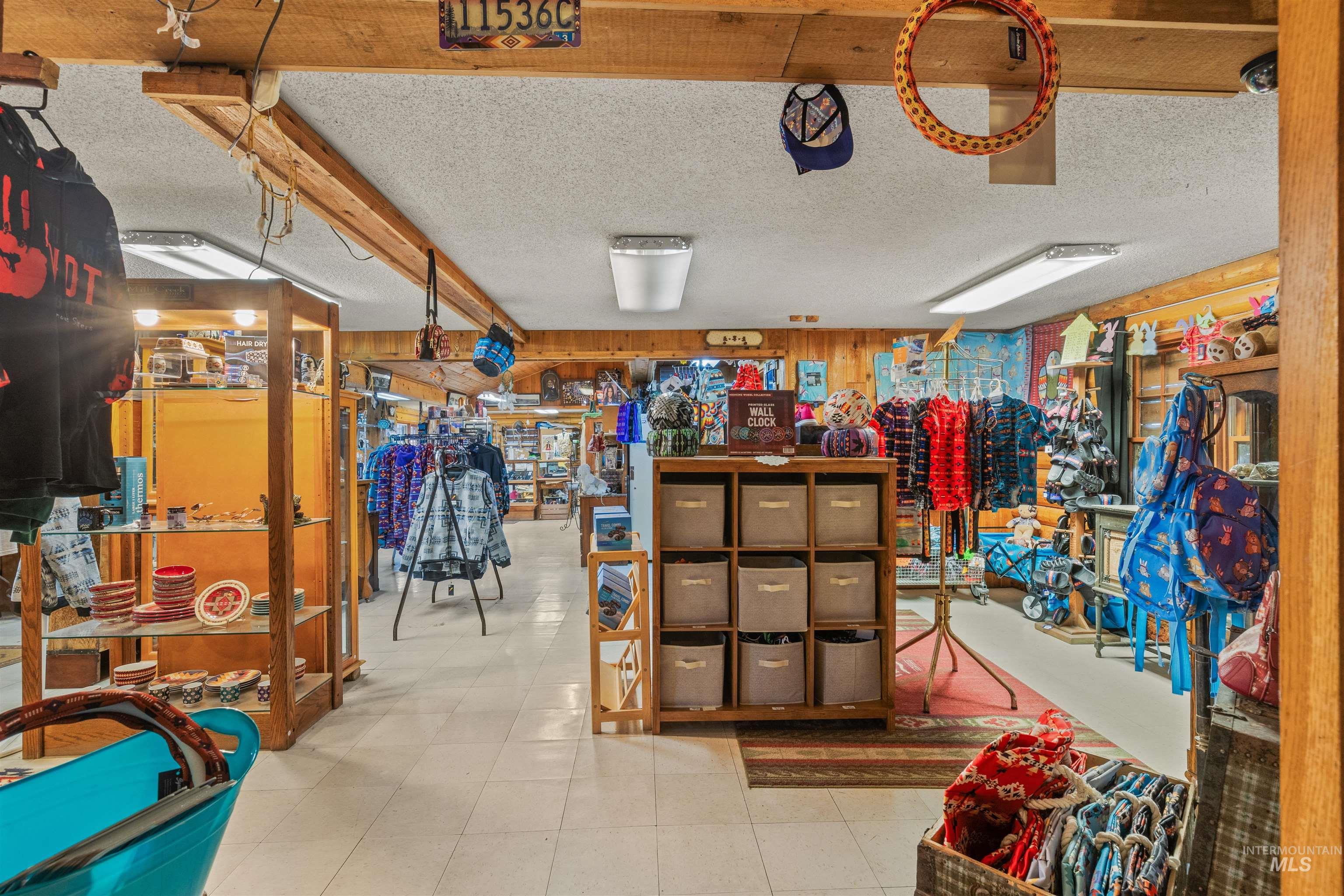 Misc room with wooden walls, a textured ceiling, and light tile patterned floors