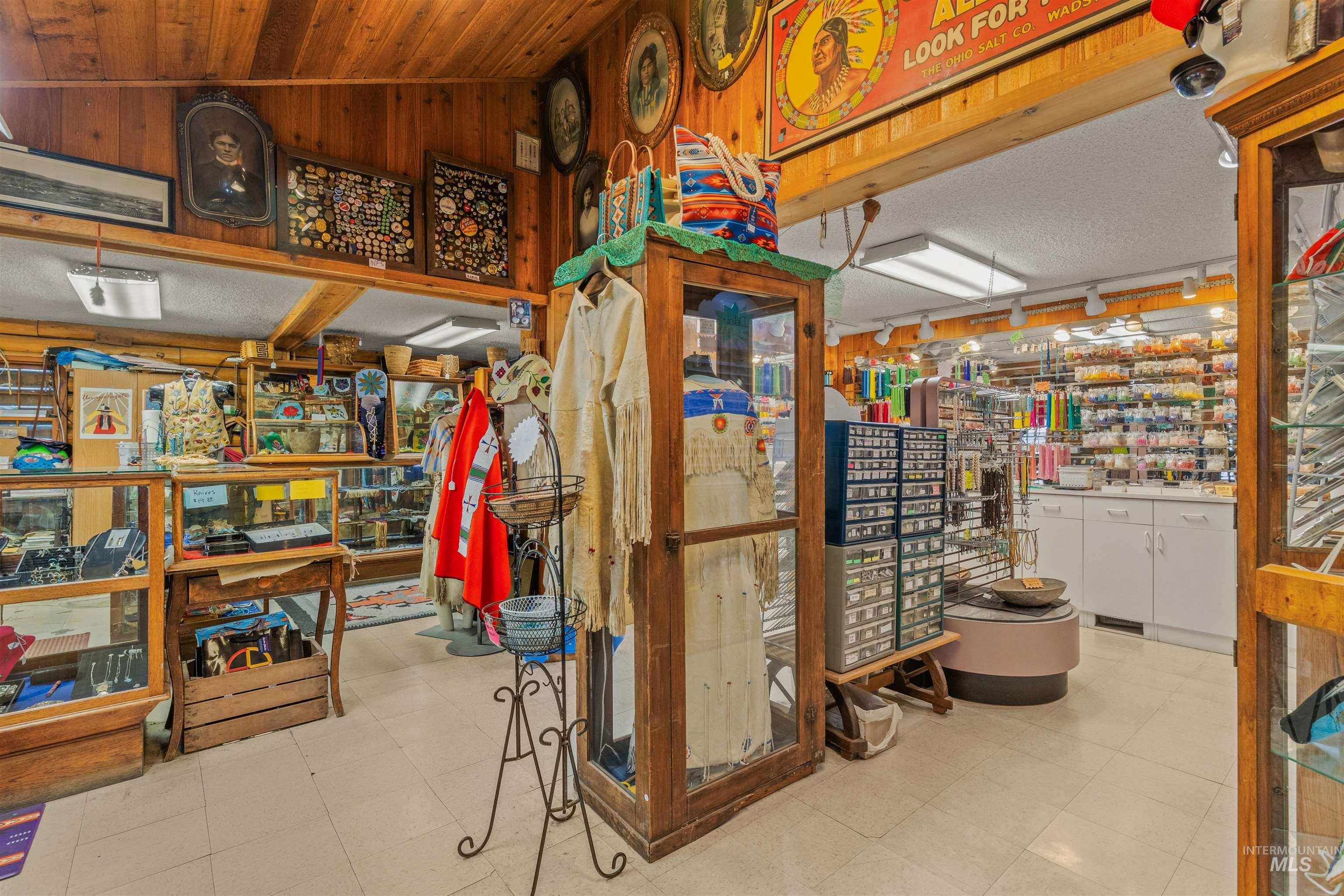 Below grade area featuring a textured ceiling, a workshop area, wooden walls, and light flooring