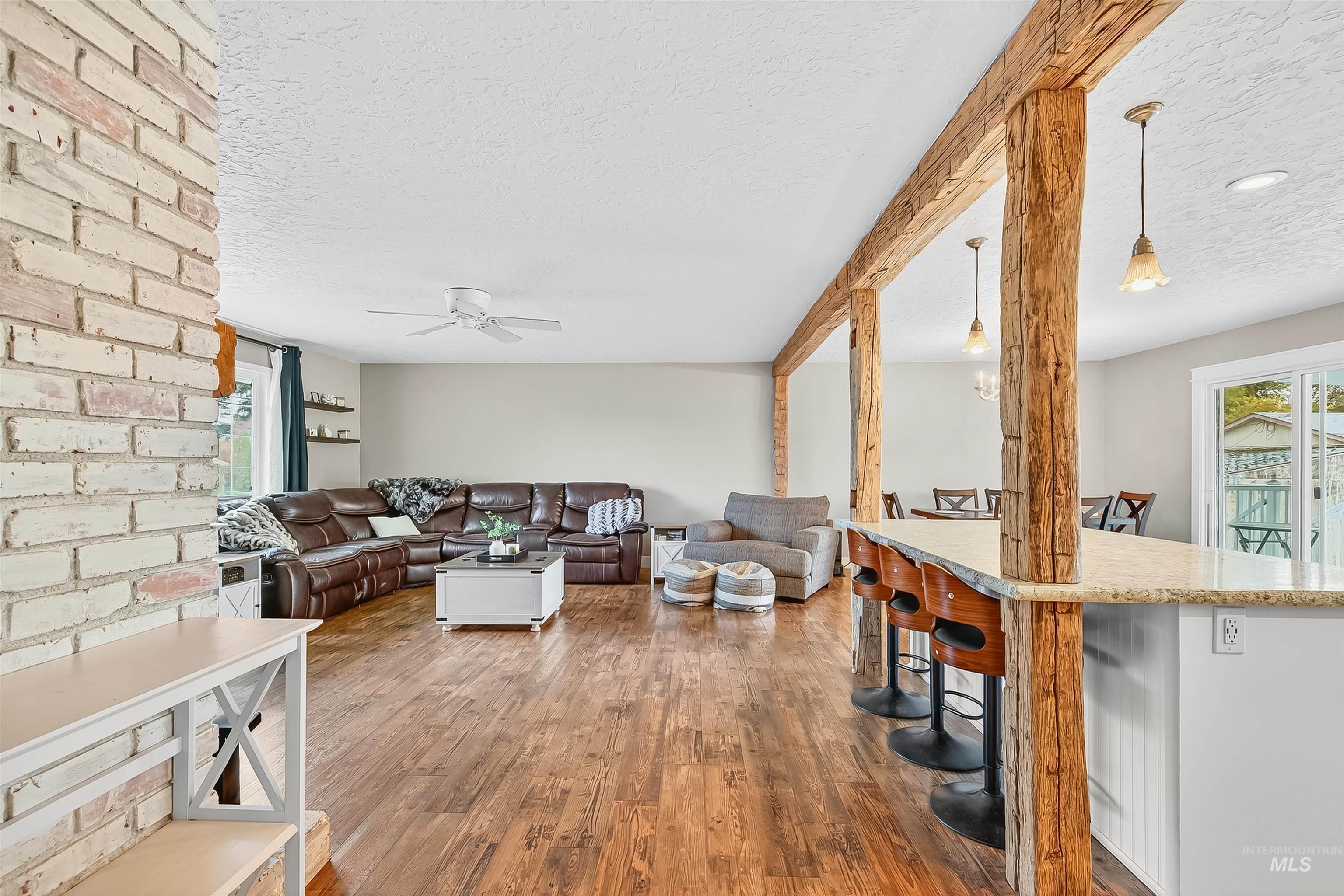 Living area featuring a textured ceiling, wood finished floors, and a ceiling fan