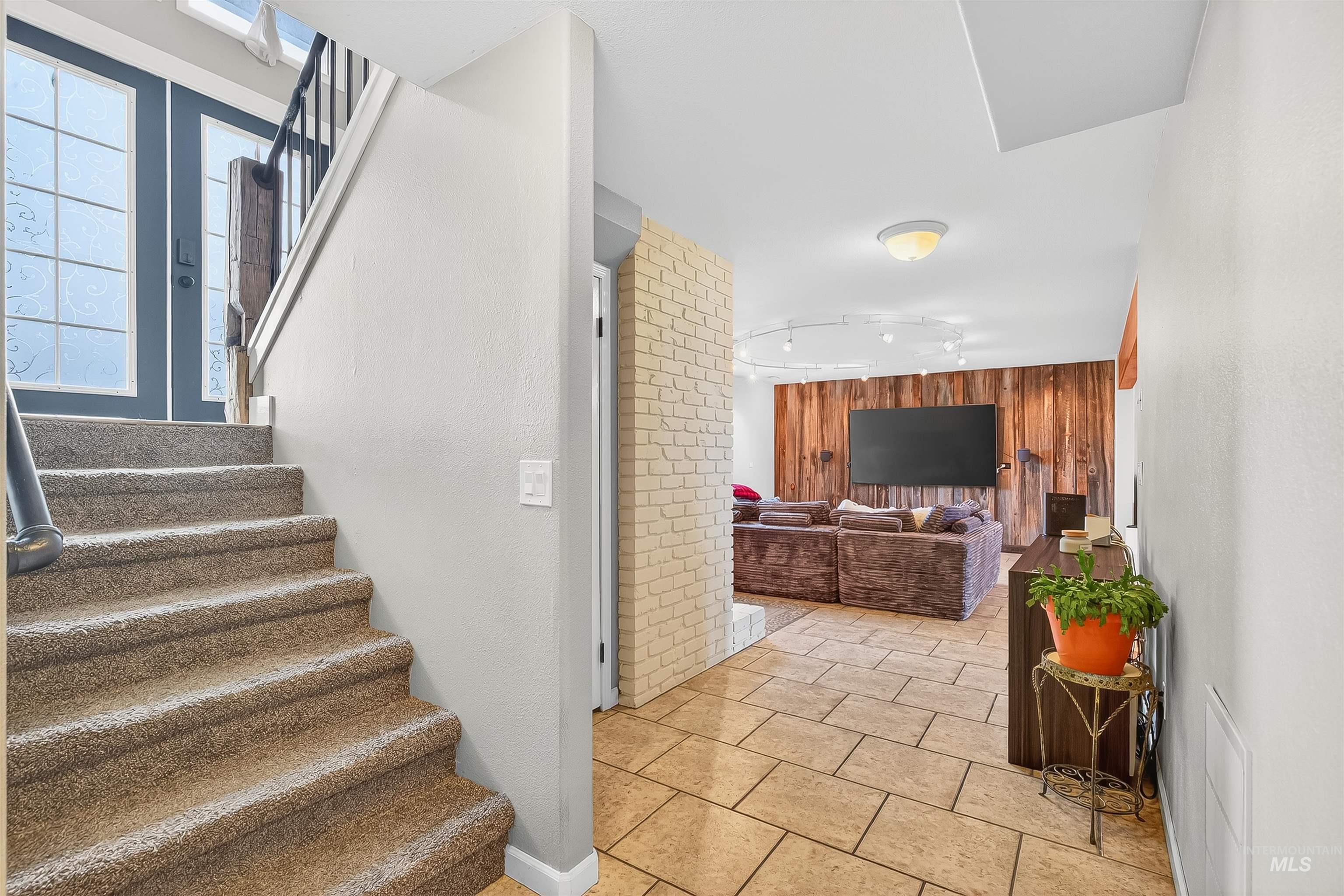 Stairs with wood walls and tile patterned flooring