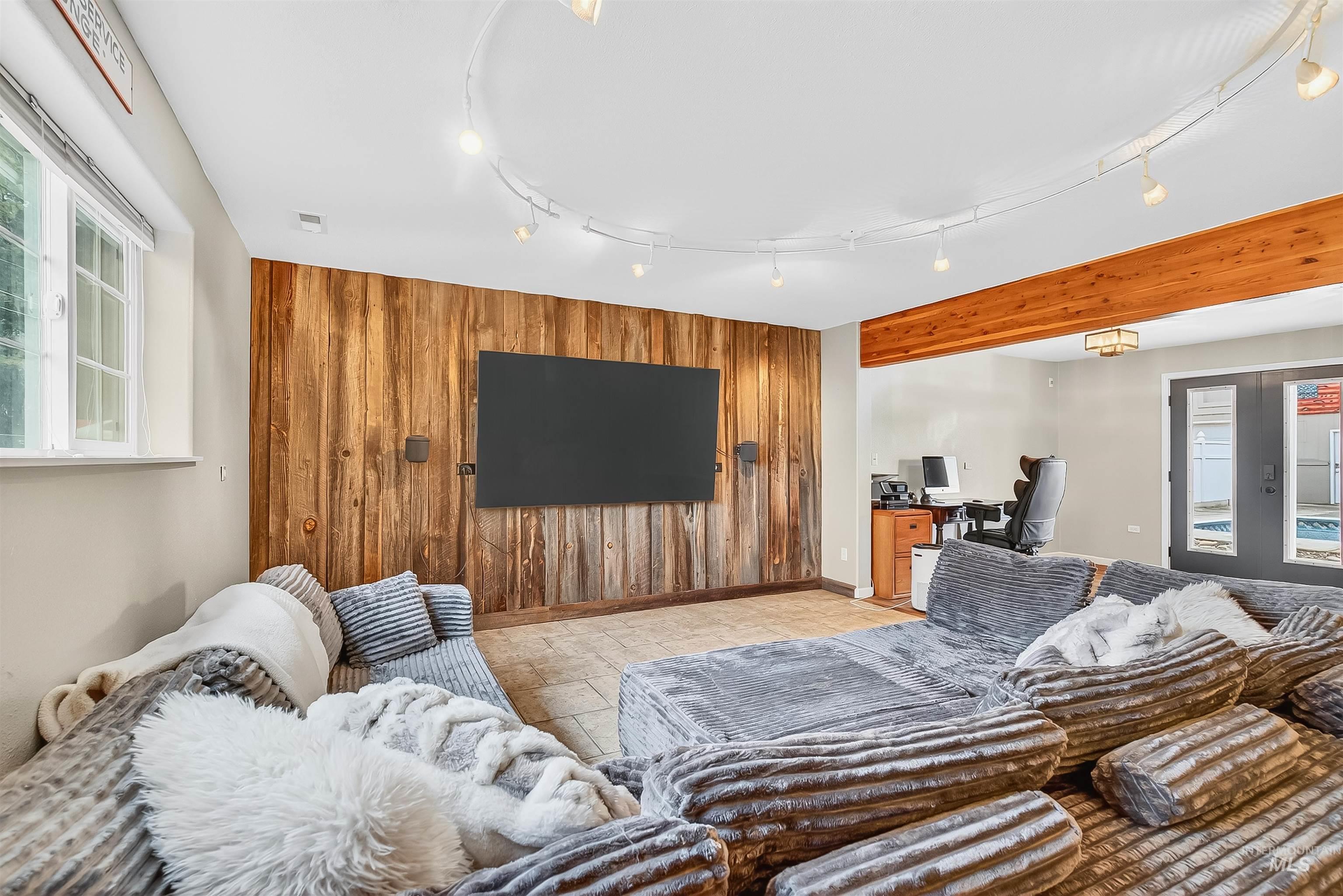 Living area with wooden walls, a desk, and an accent wall