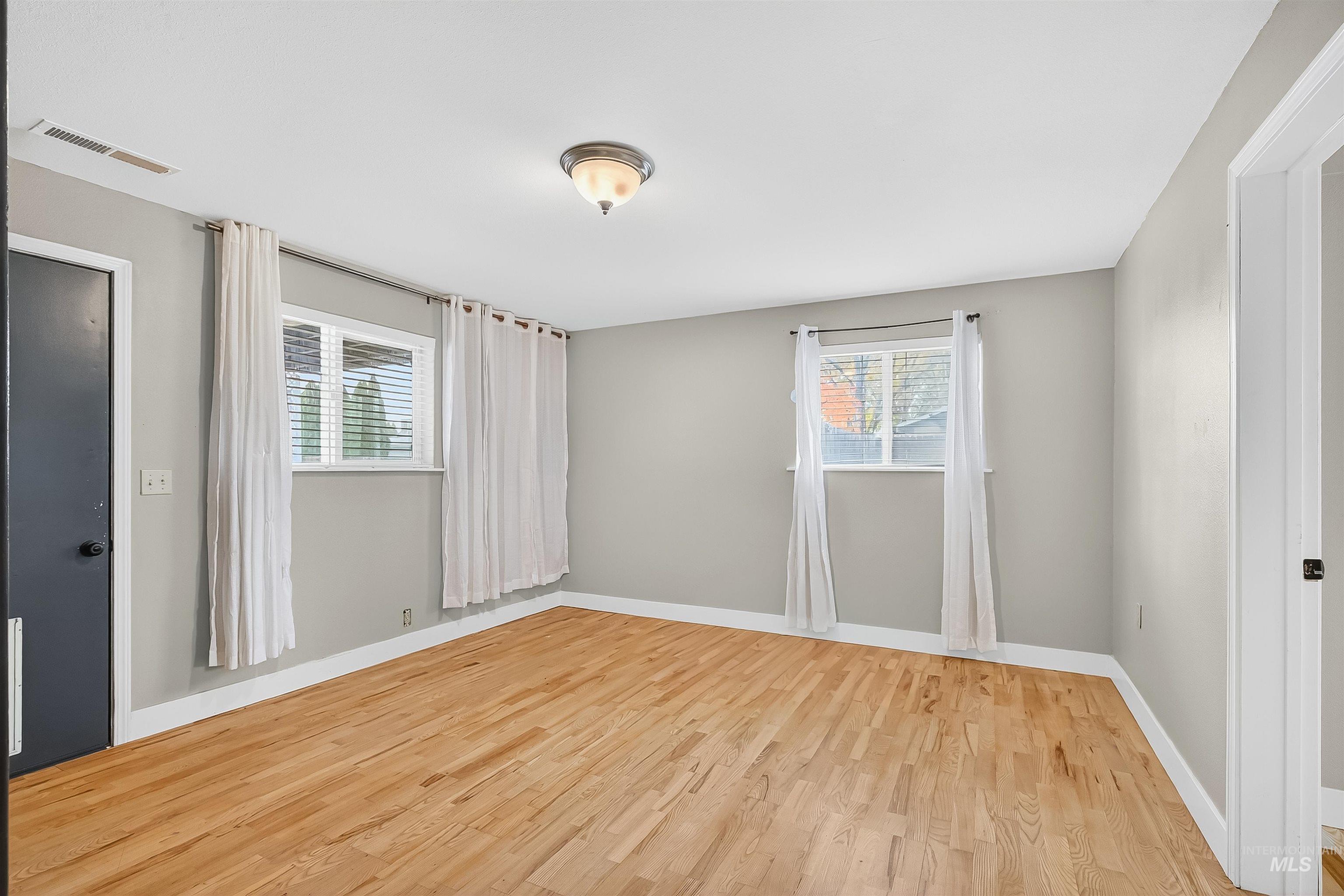 Unfurnished room featuring wood finished floors and healthy amount of natural light