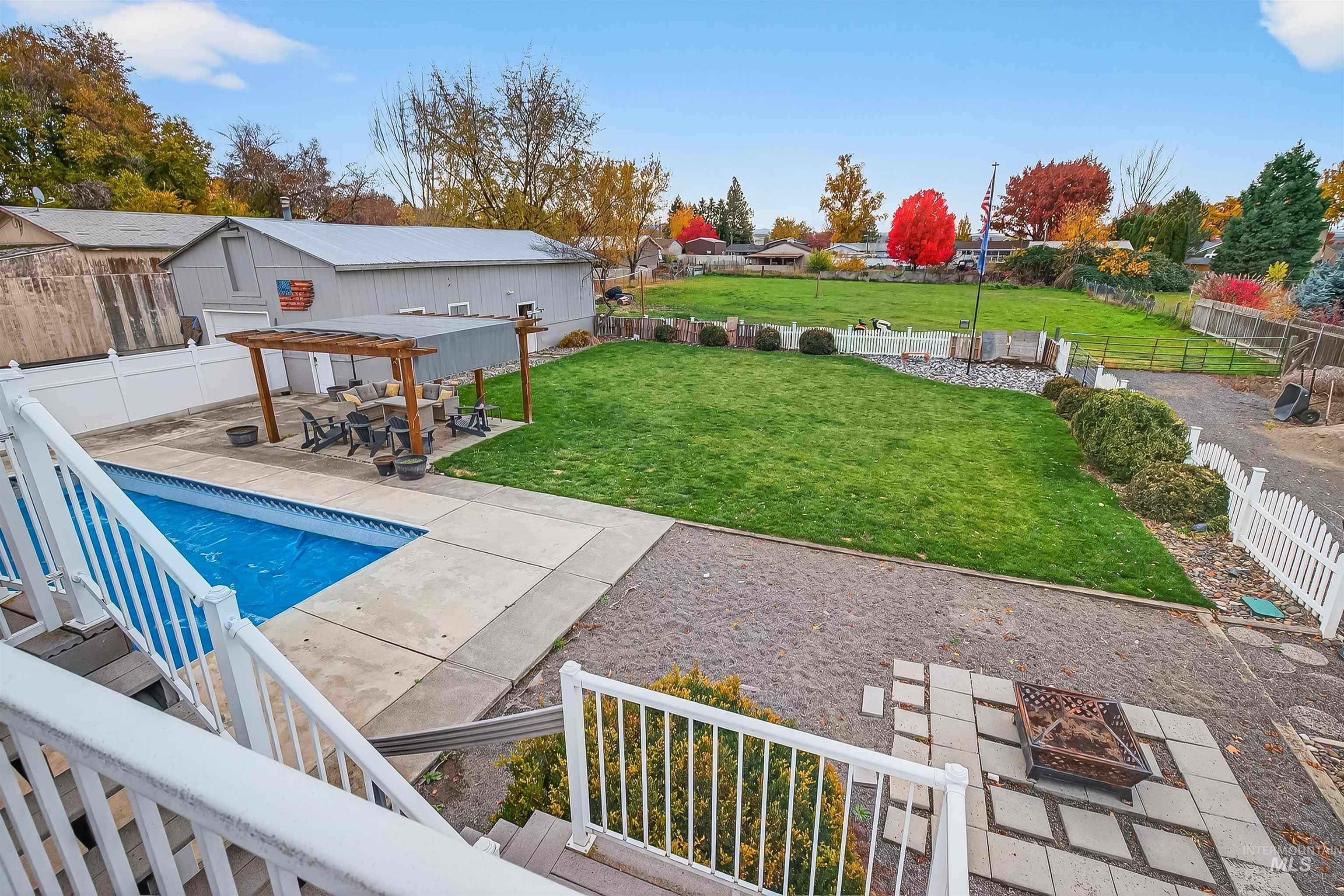 Fenced backyard with a patio area, a fire pit, and a pergola