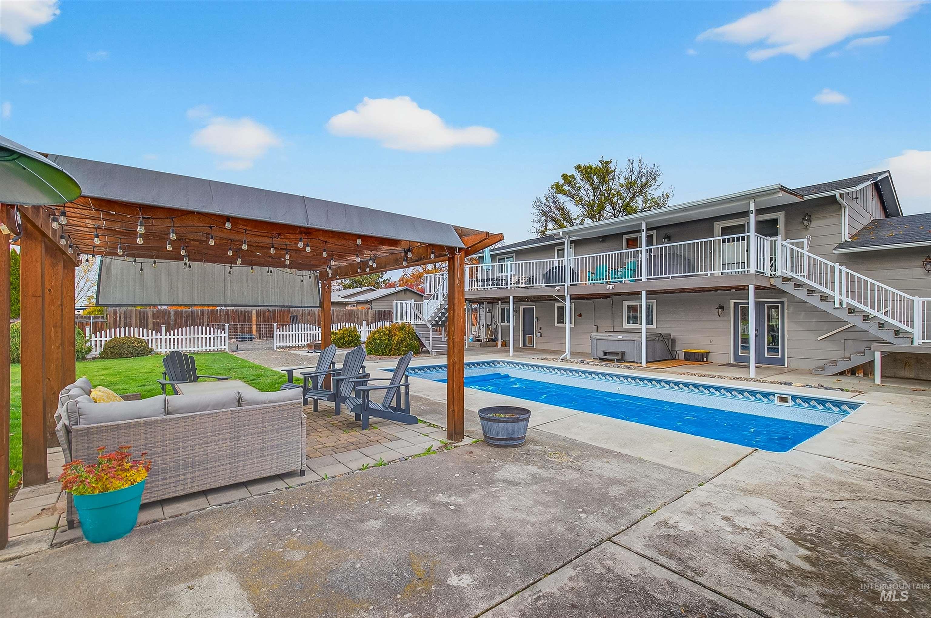 View of pool featuring stairs, a patio, a jacuzzi, outdoor lounge area, and a fenced backyard