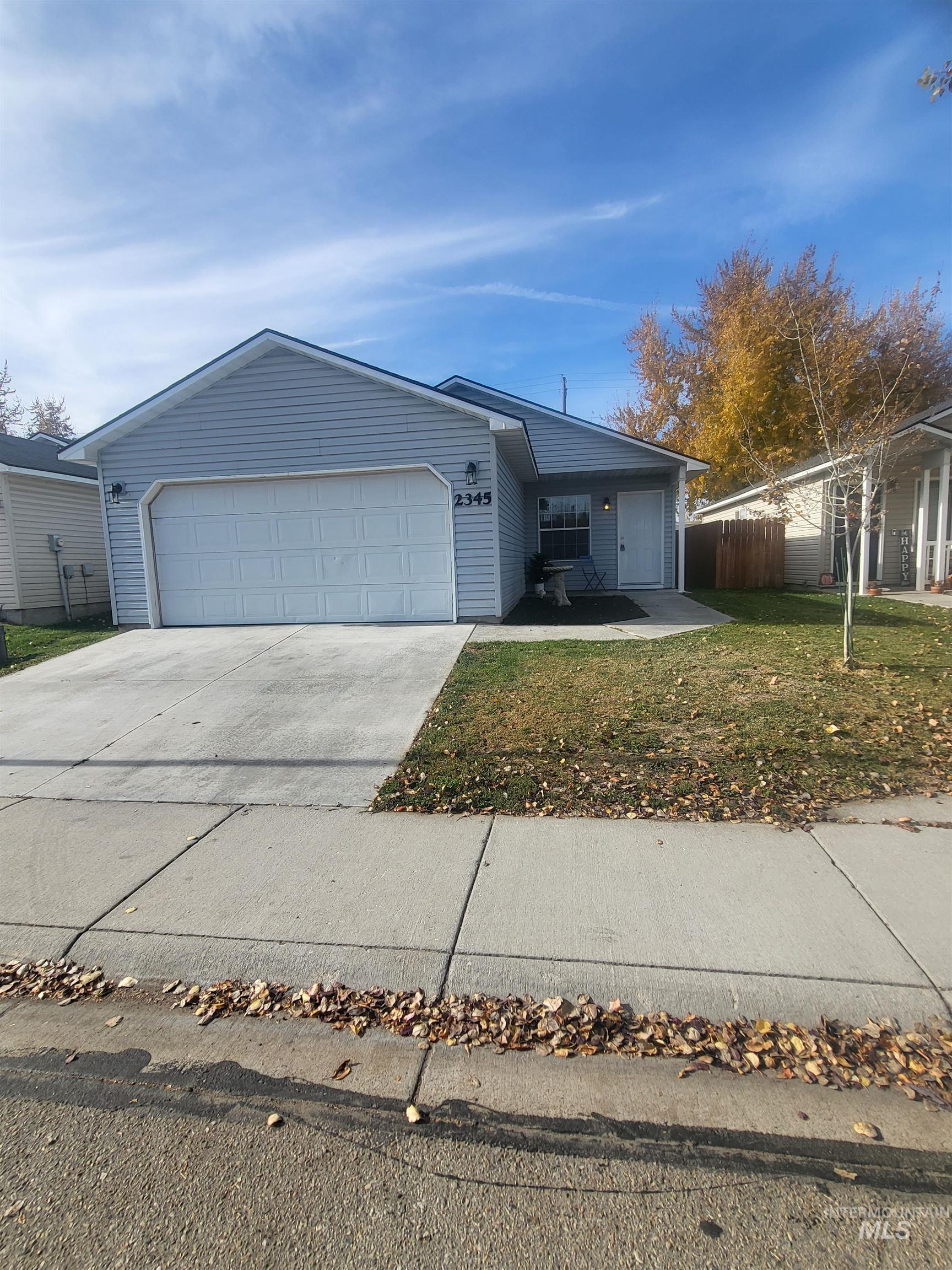 Ranch-style home featuring driveway and an attached garage