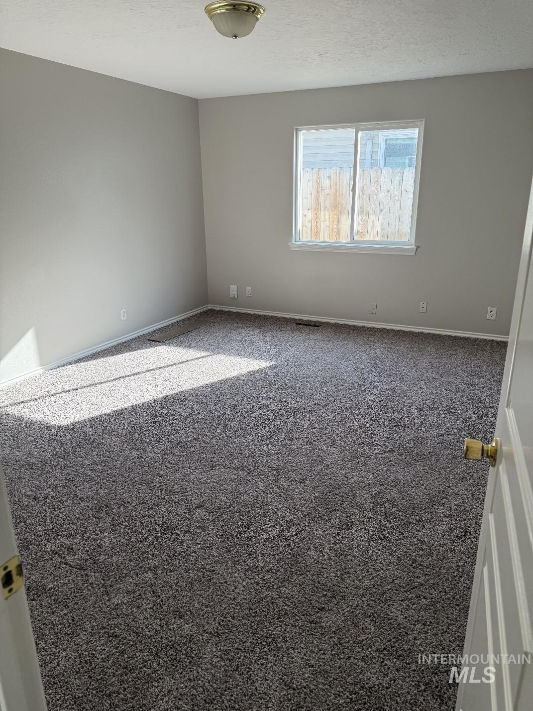 Spare room featuring carpet and a textured ceiling