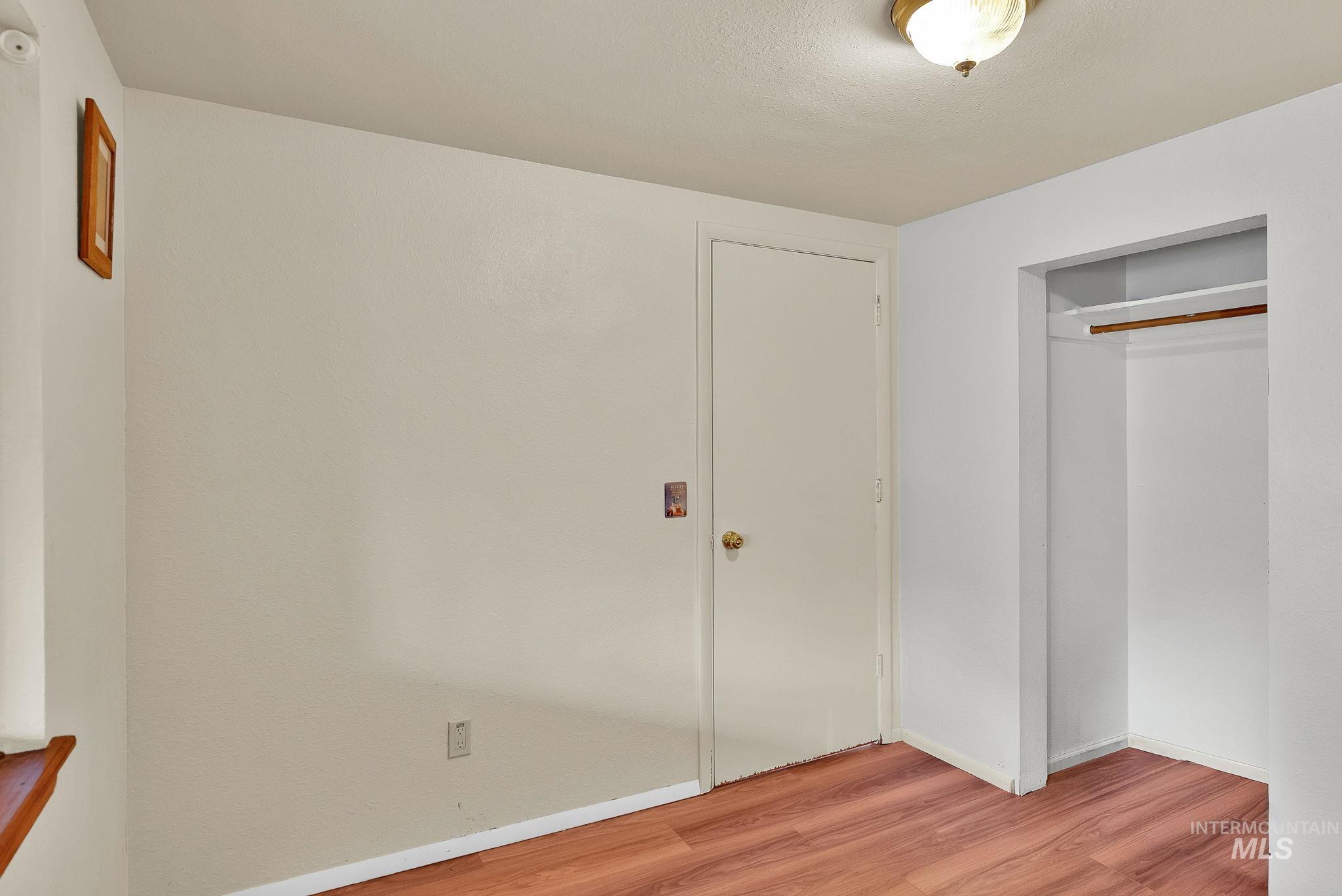 Unfurnished bedroom featuring light wood finished floors and a closet