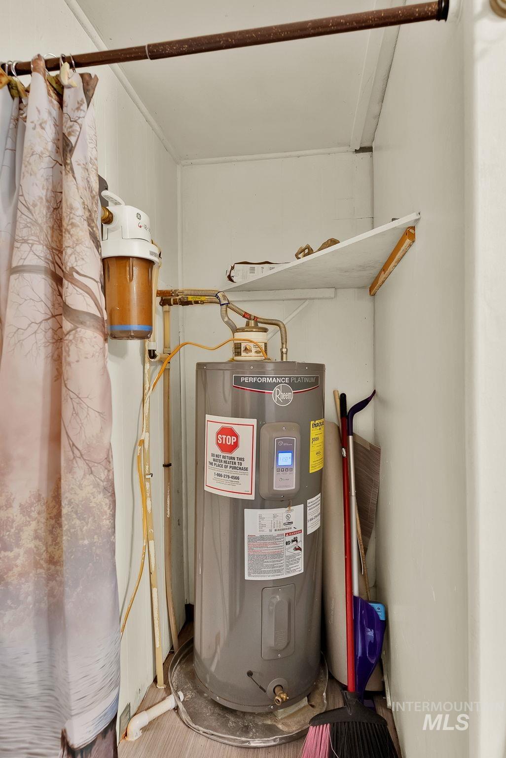 Utility room with electric water heater and a central vacuum unit