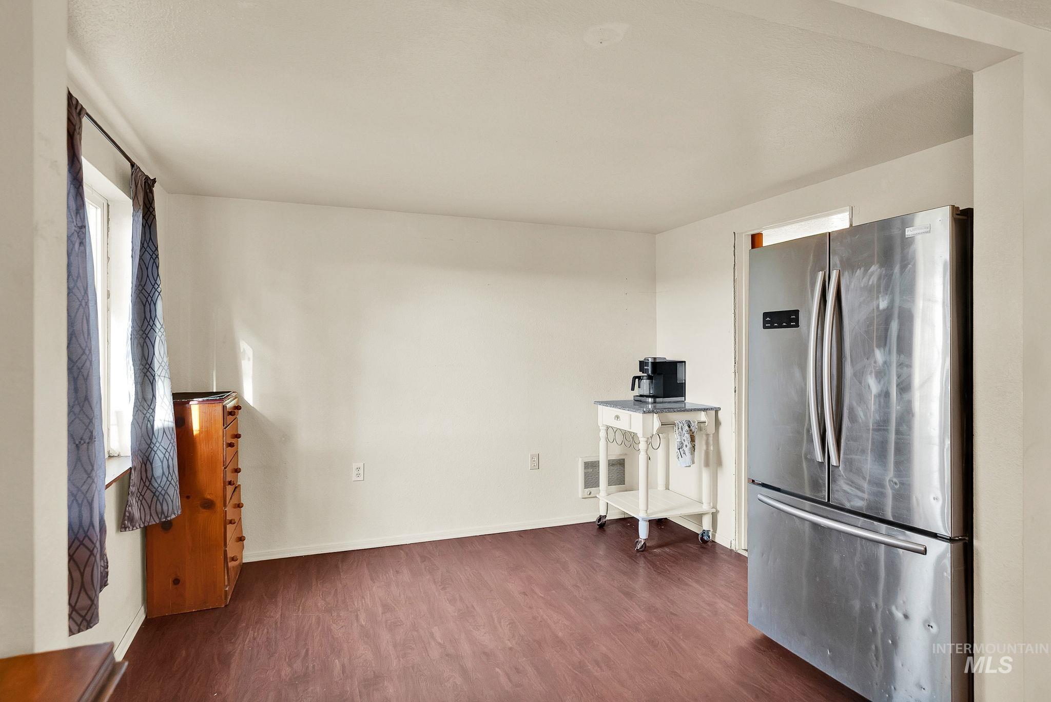 Kitchen featuring freestanding refrigerator and dark wood finished floors