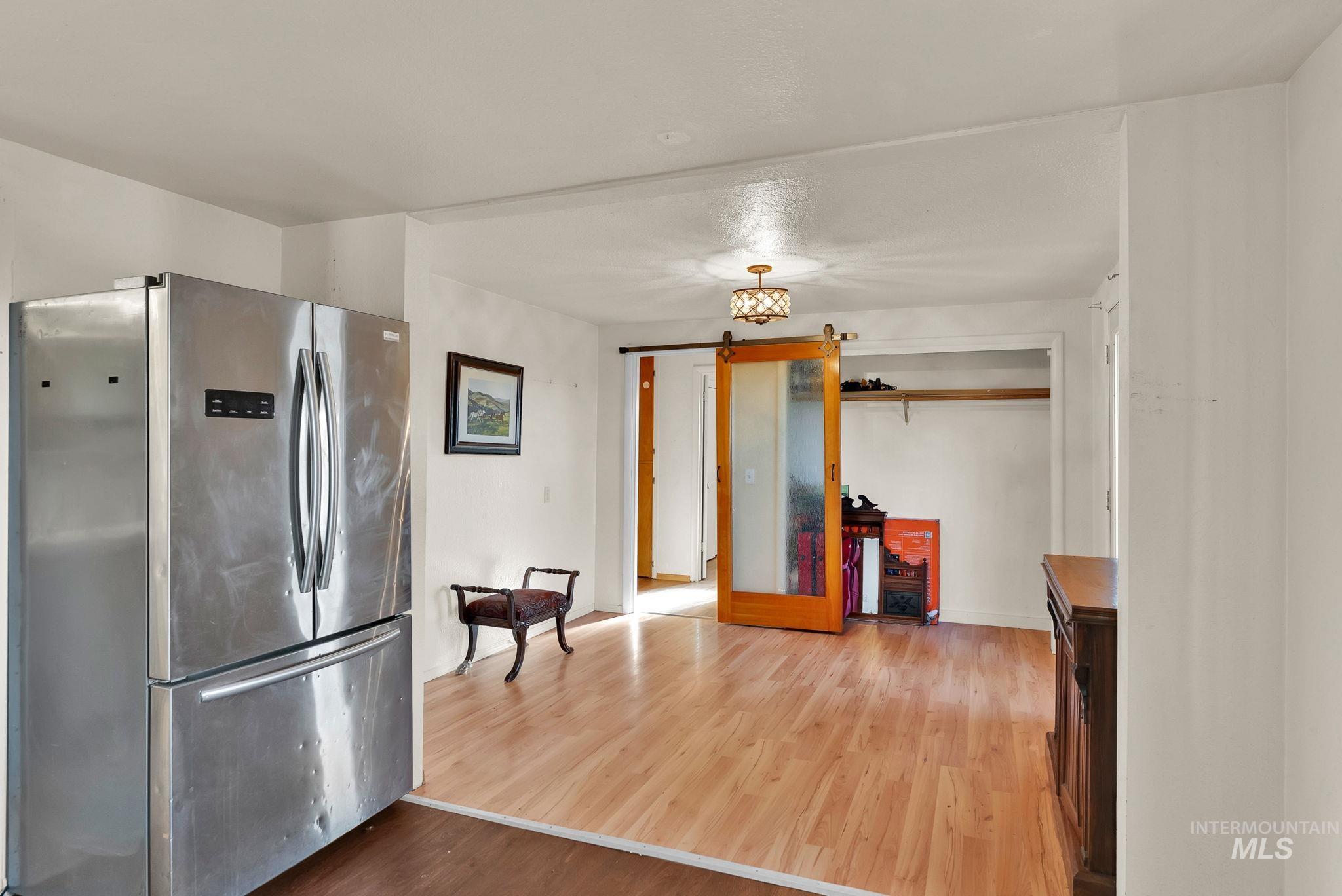Kitchen featuring freestanding refrigerator and wood finished floors