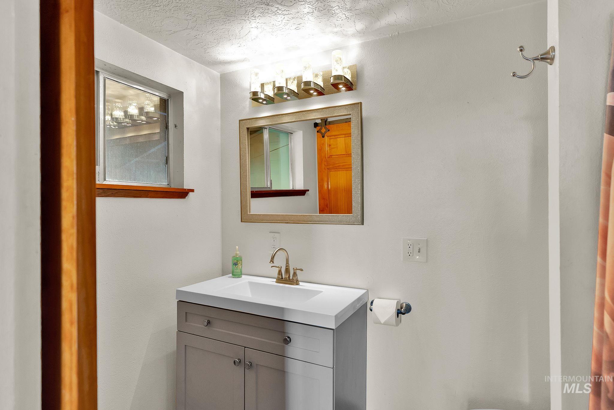 Bathroom featuring a textured ceiling and vanity