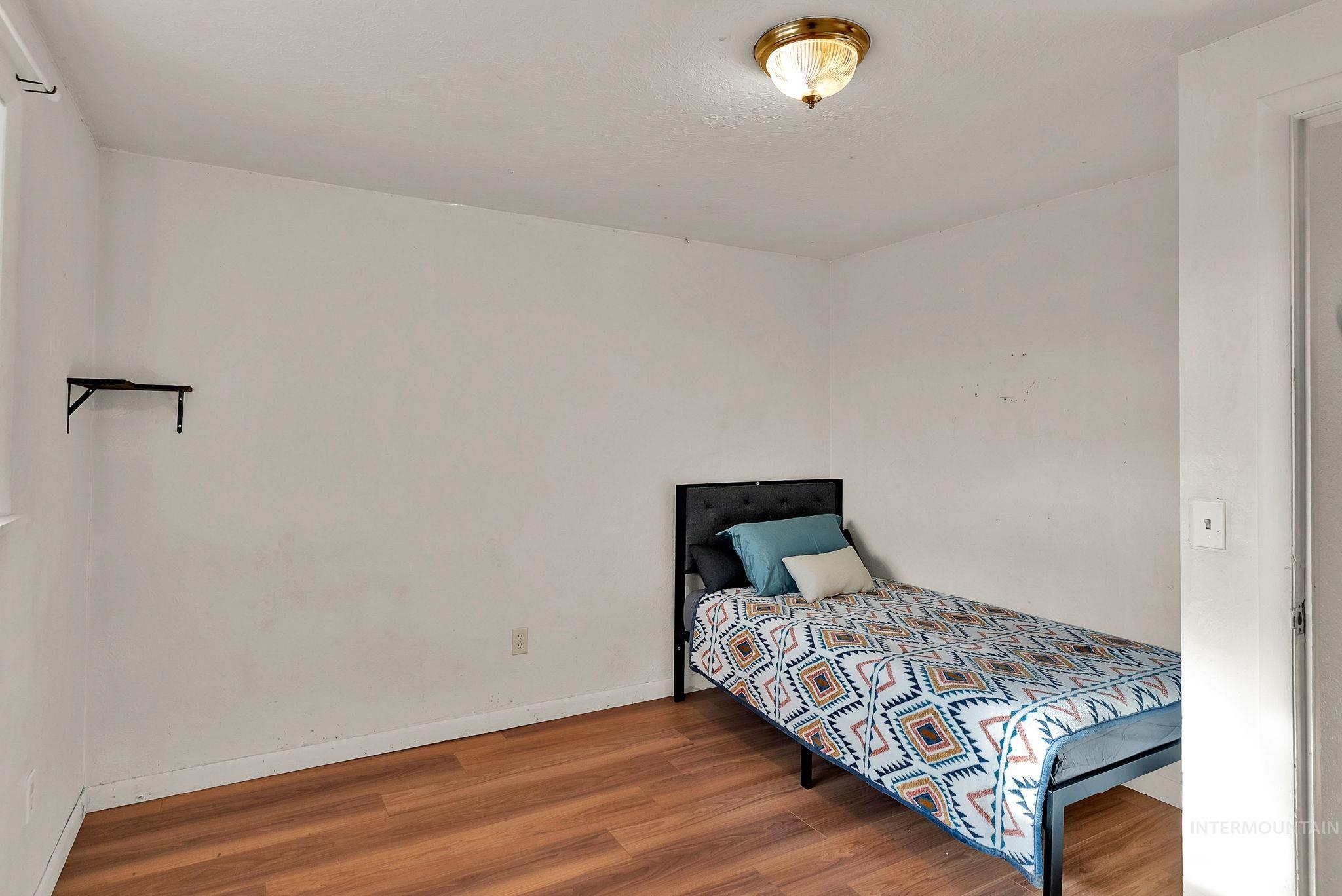 Bedroom featuring wood finished floors and baseboards