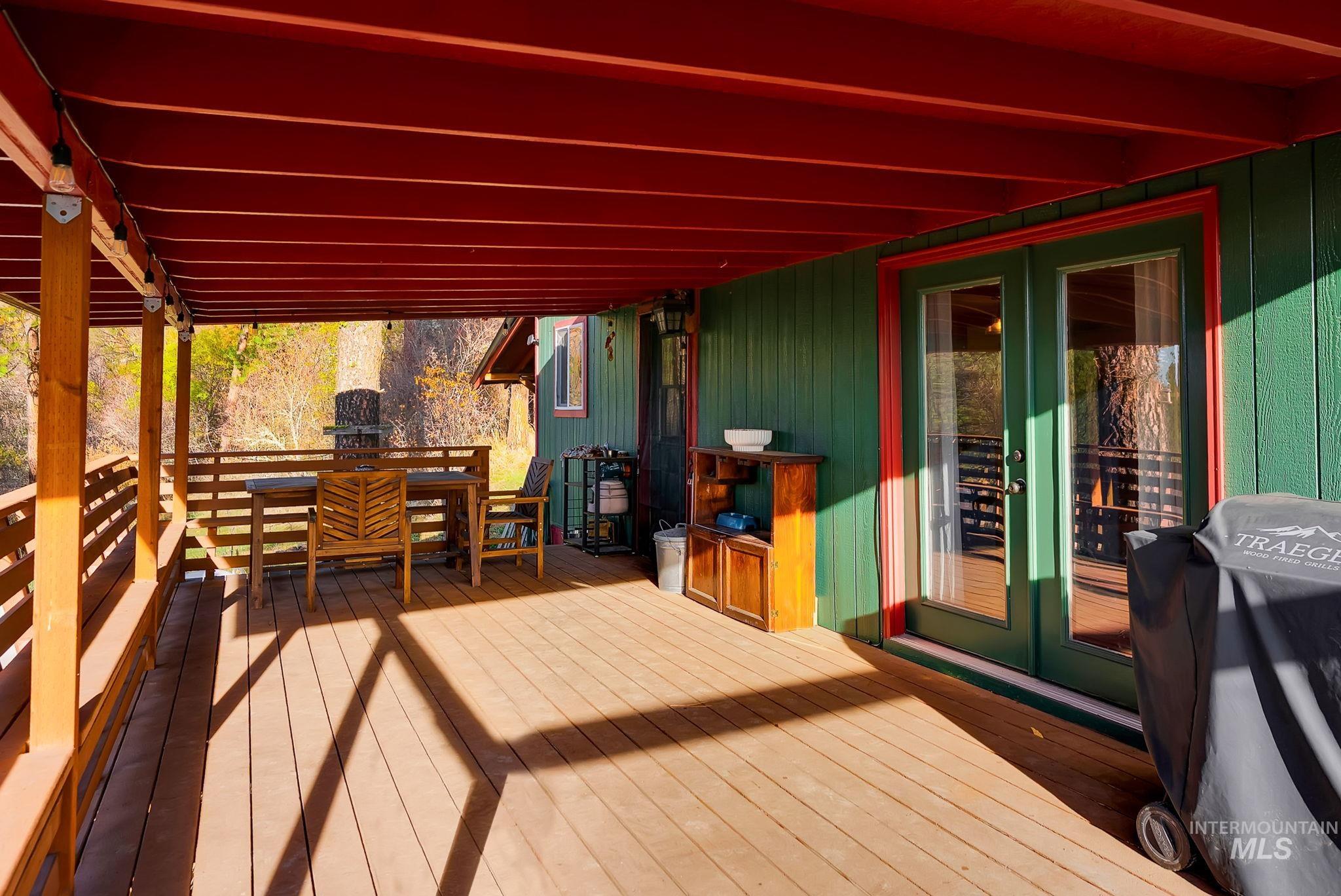 Wooden terrace featuring french doors and outdoor dining space