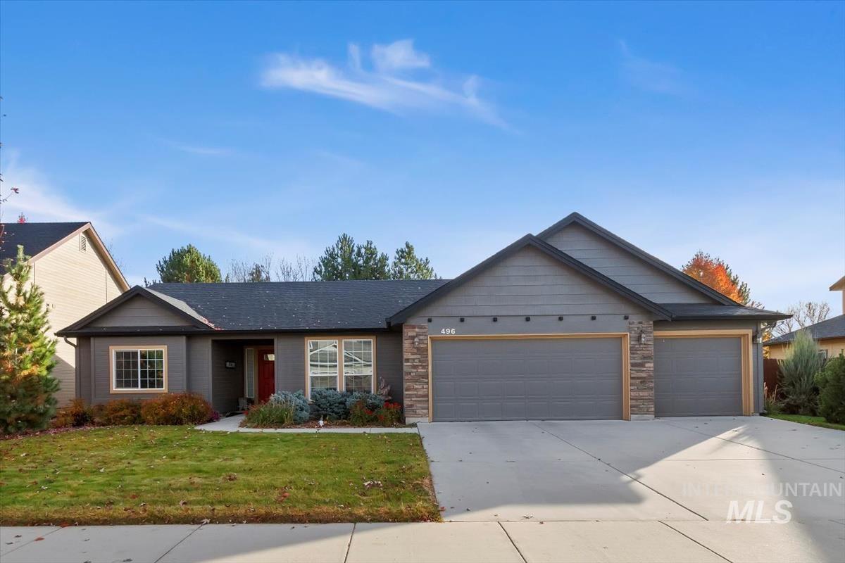Ranch-style home with a garage, concrete driveway, a front yard, and stone siding