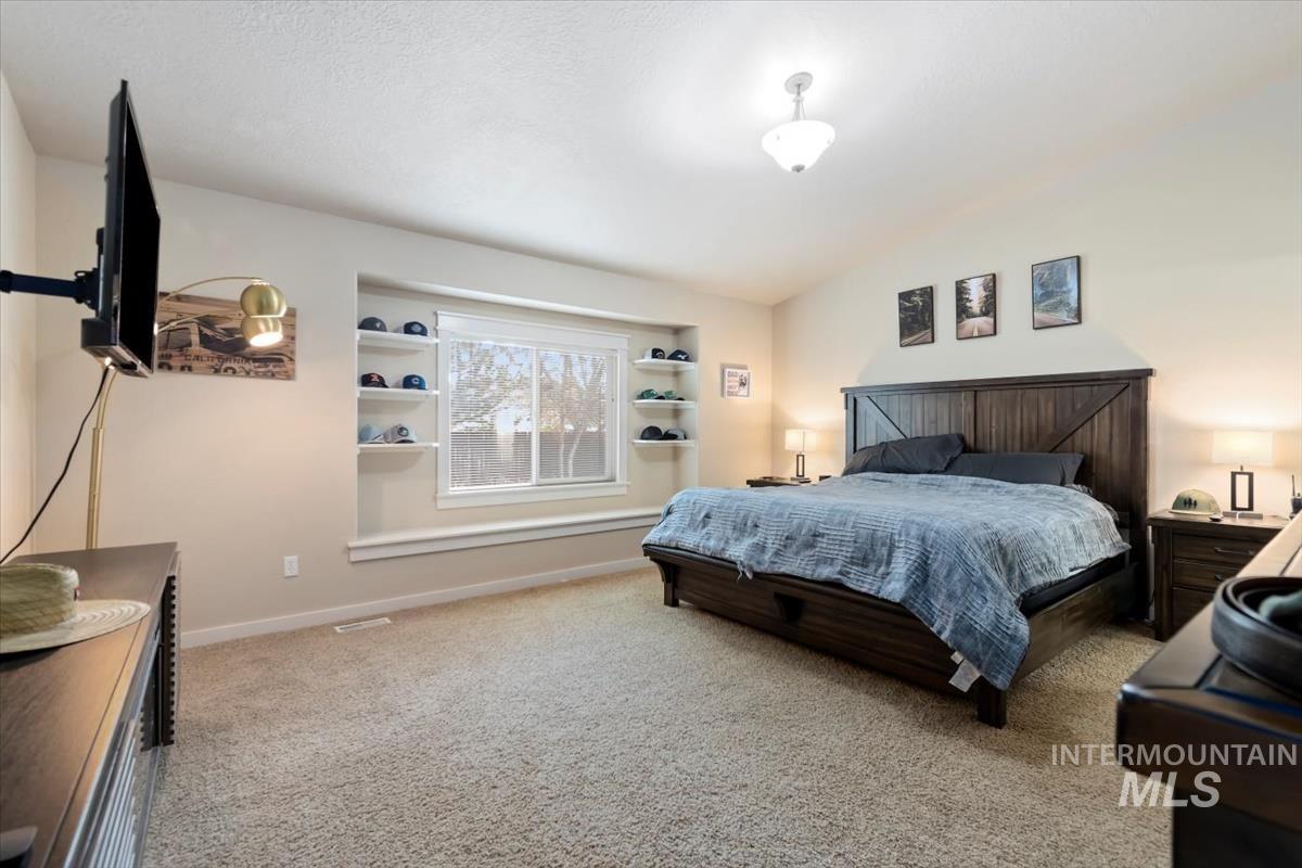 Bedroom featuring light colored carpet and baseboards