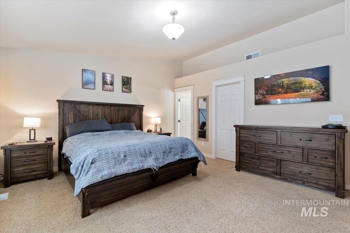 Bedroom featuring light carpet and lofted ceiling