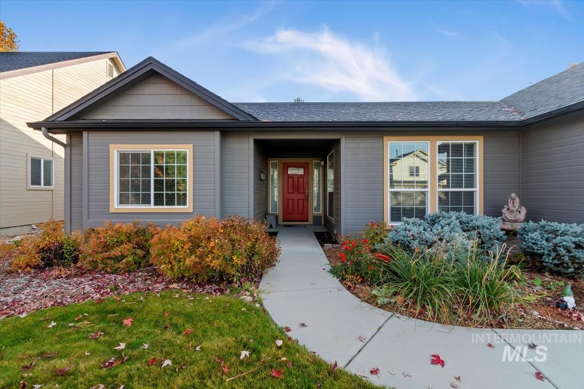 Doorway to property with a yard and roof with shingles