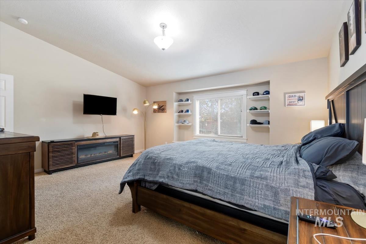 Carpeted bedroom featuring lofted ceiling