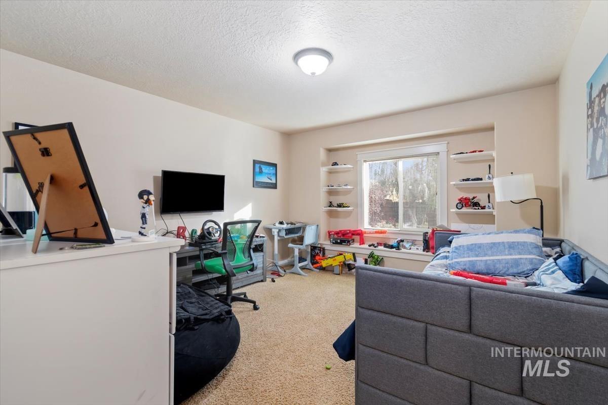 Office area featuring light colored carpet and a textured ceiling
