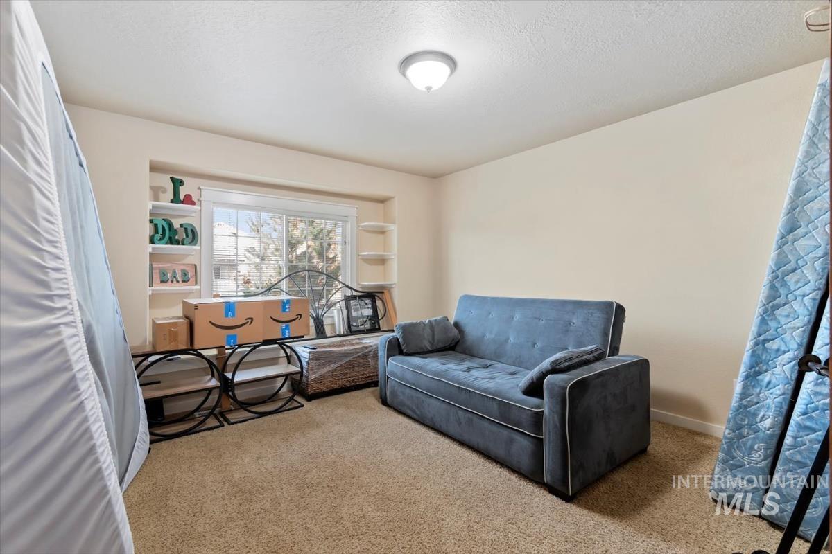 Sitting room featuring carpet flooring and a textured ceiling