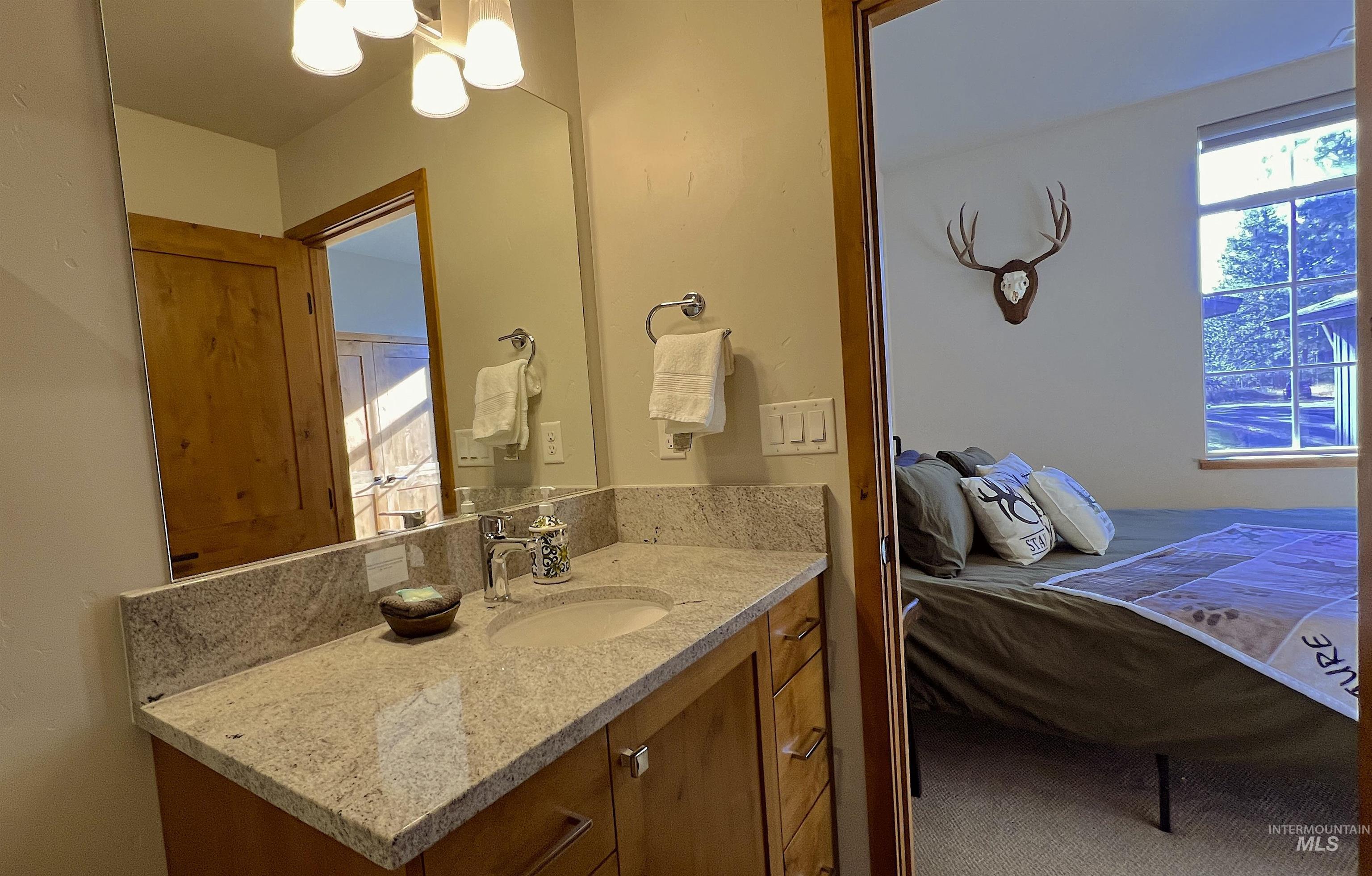 Ensuite bathroom featuring vanity and a chandelier