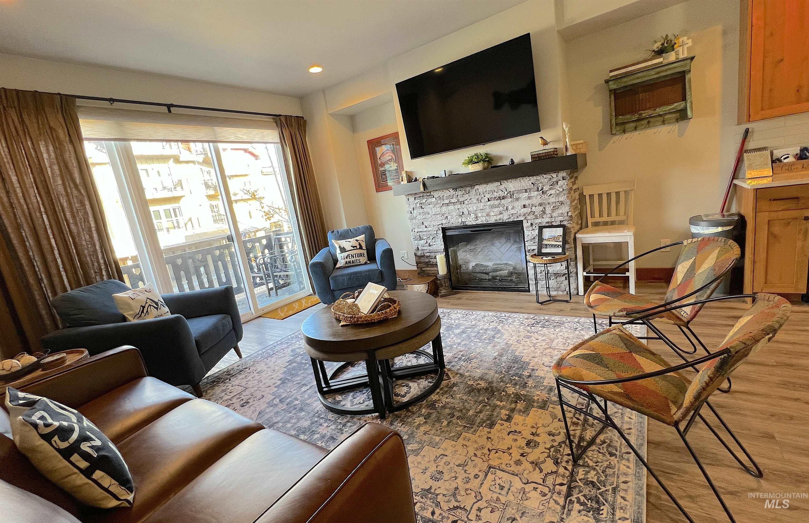 Living area with a fireplace, light wood finished floors, and recessed lighting