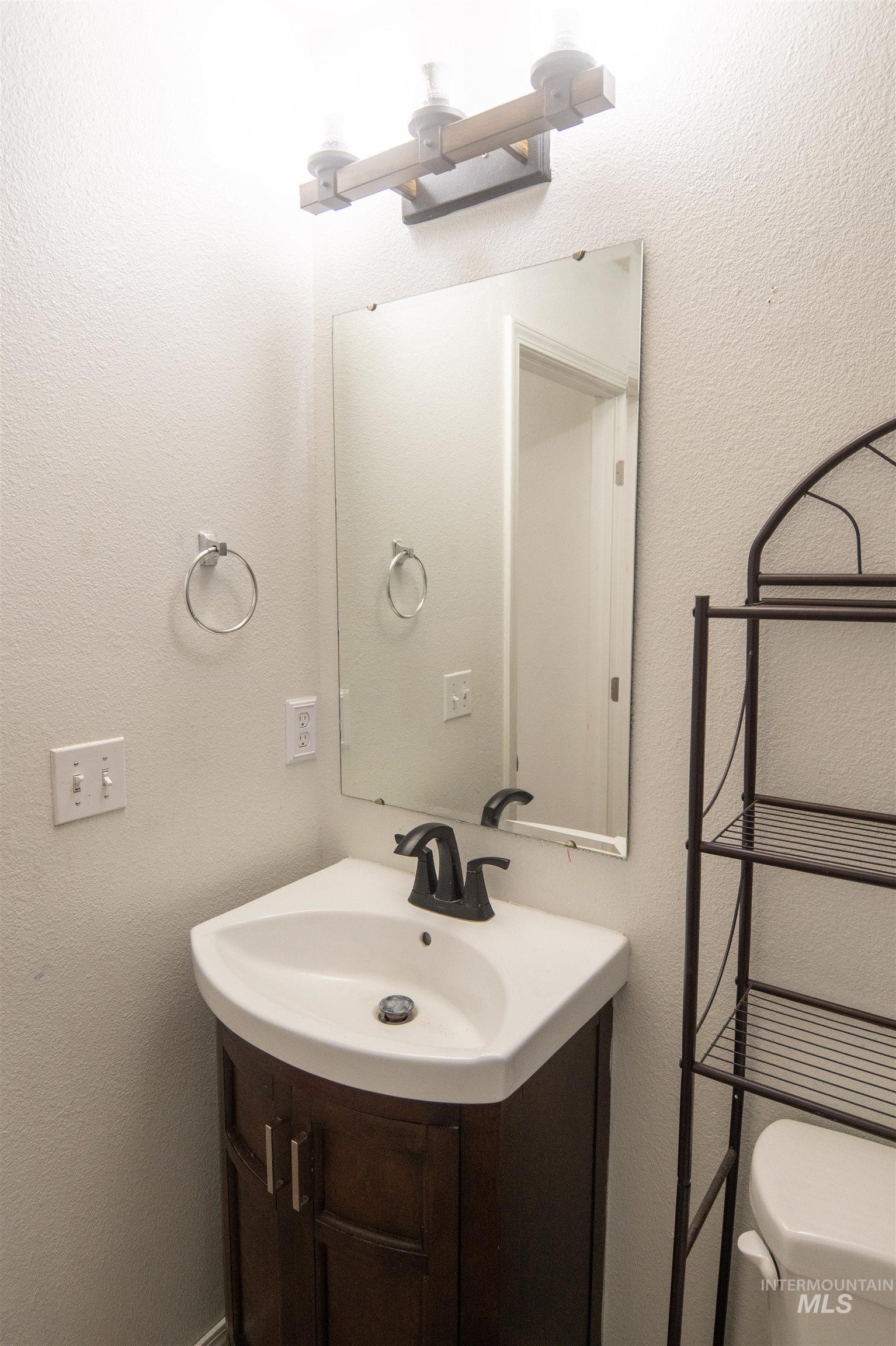 Bathroom with a textured wall and vanity