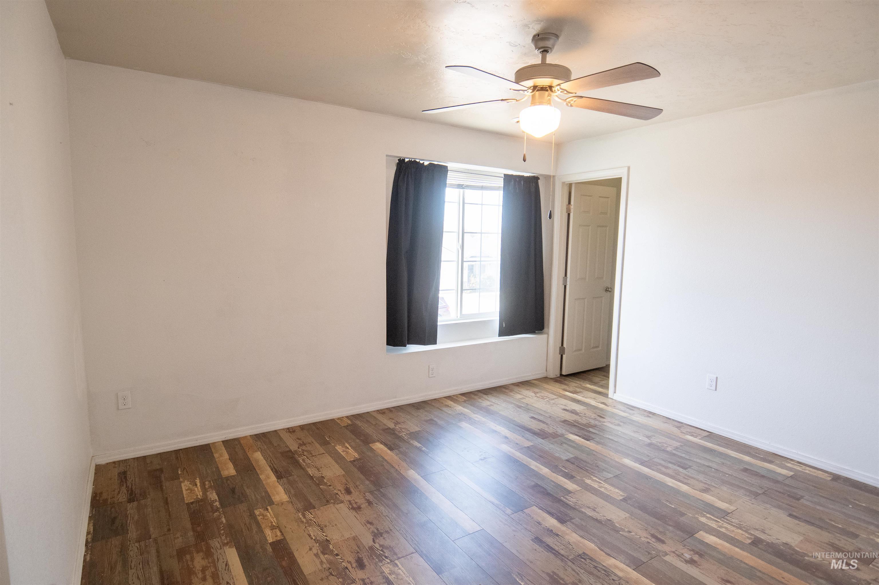 Unfurnished room featuring wood finished floors and a ceiling fan