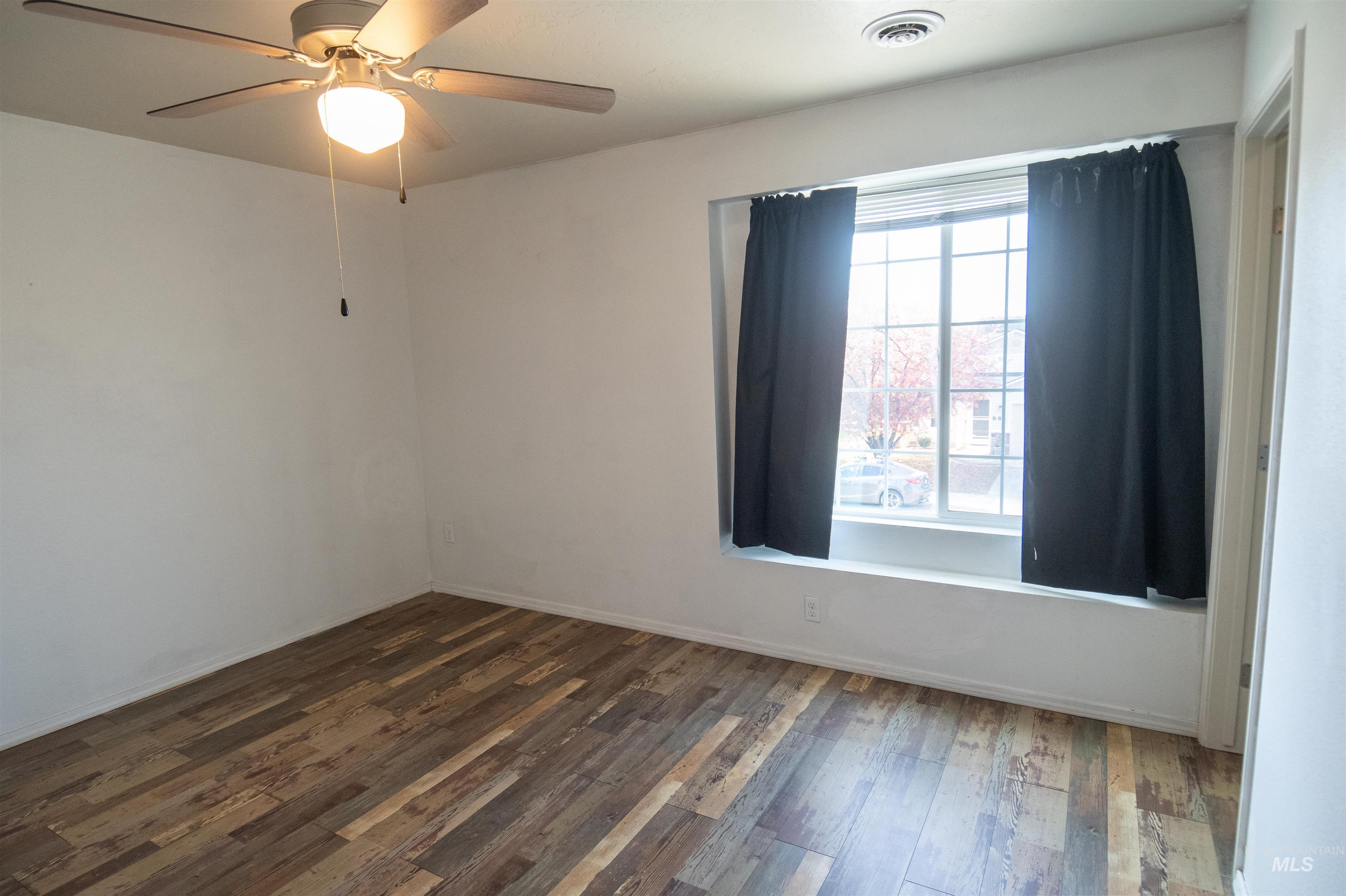 Empty room with wood finished floors and ceiling fan