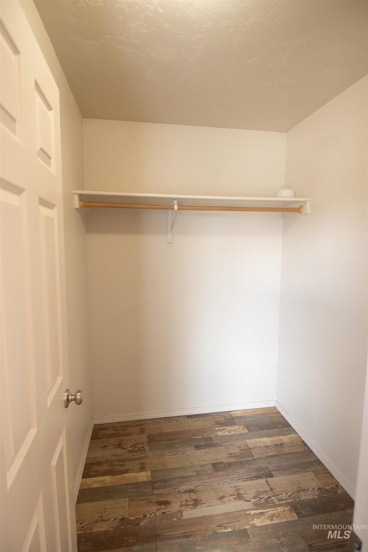 Walk in closet featuring dark wood finished floors