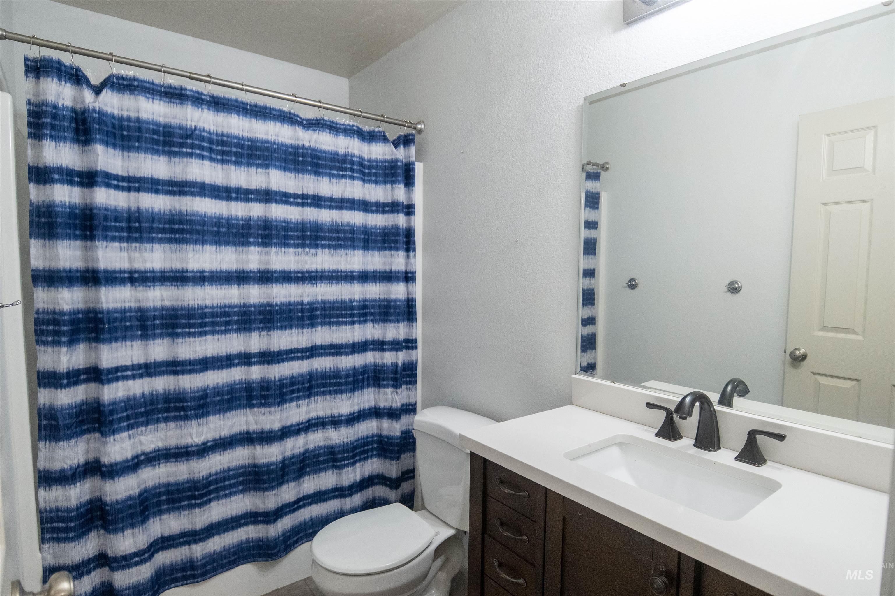 Bathroom with vanity and a shower with shower curtain