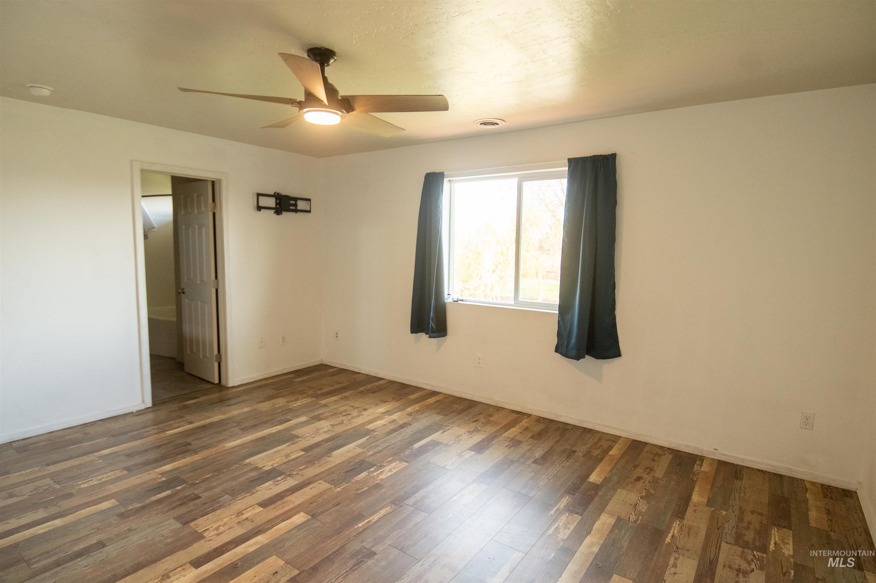Unfurnished bedroom with wood finished floors and a ceiling fan