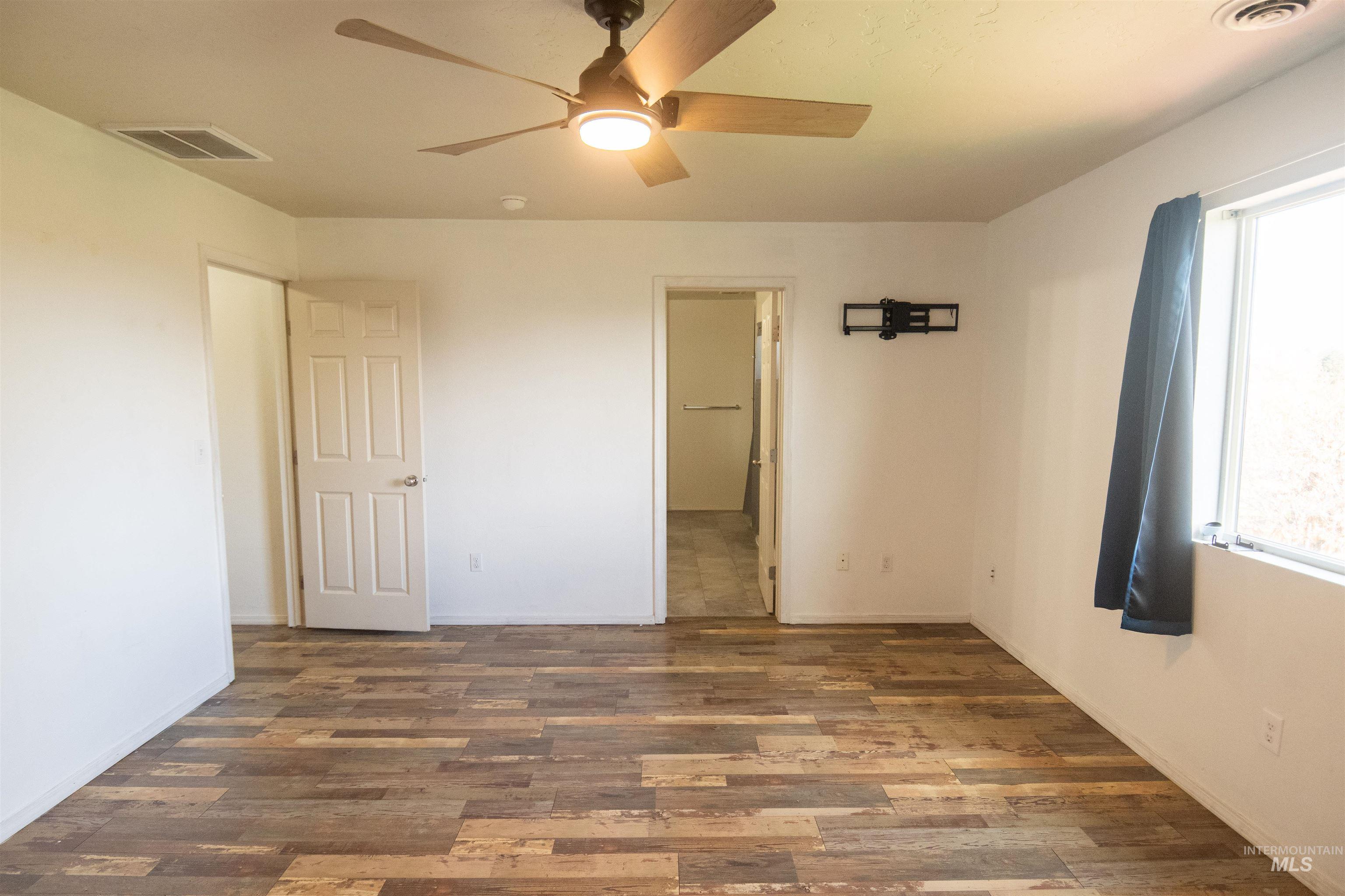Unfurnished bedroom with wood finished floors and ceiling fan