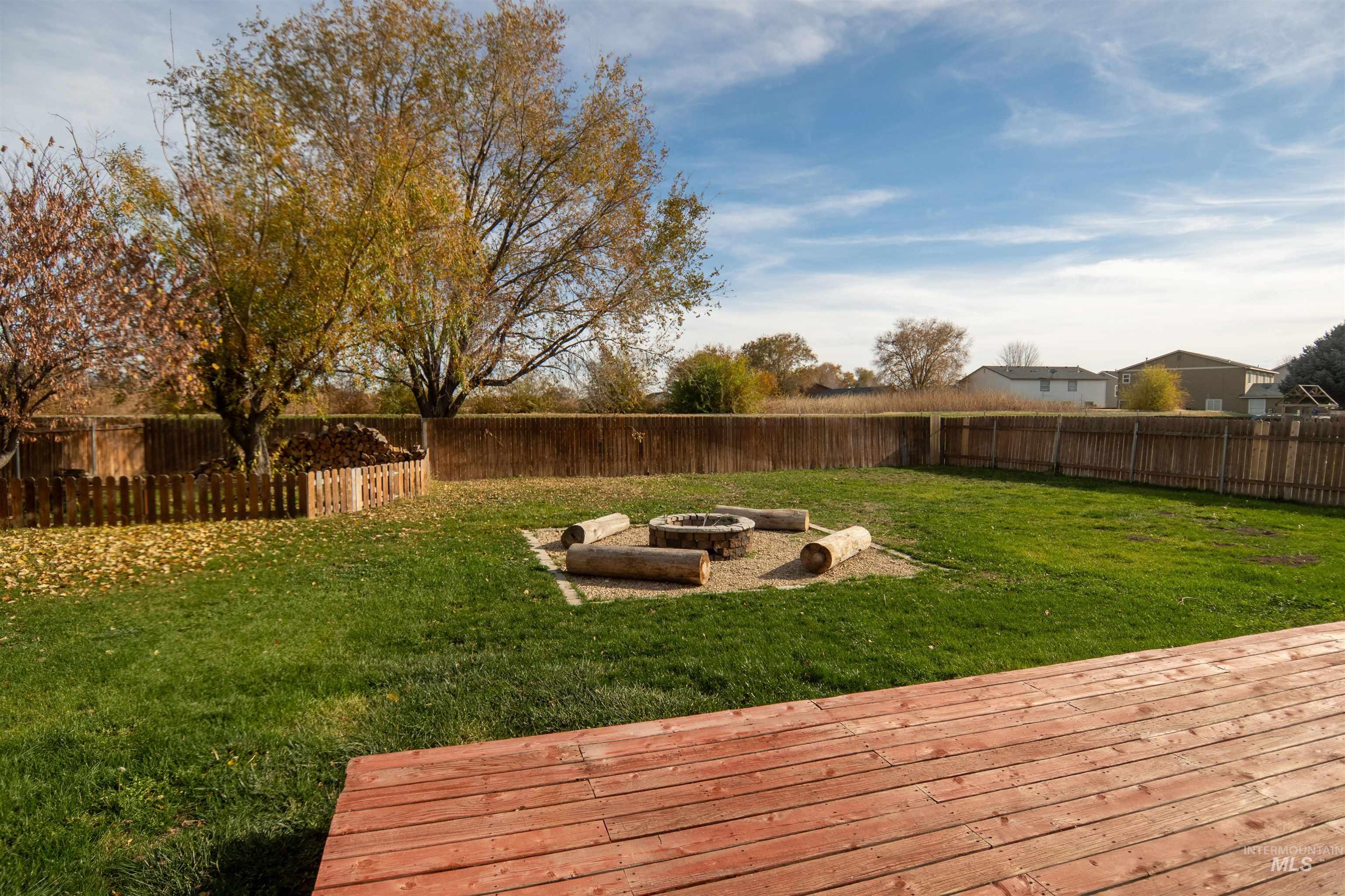 Fenced backyard with a fire pit