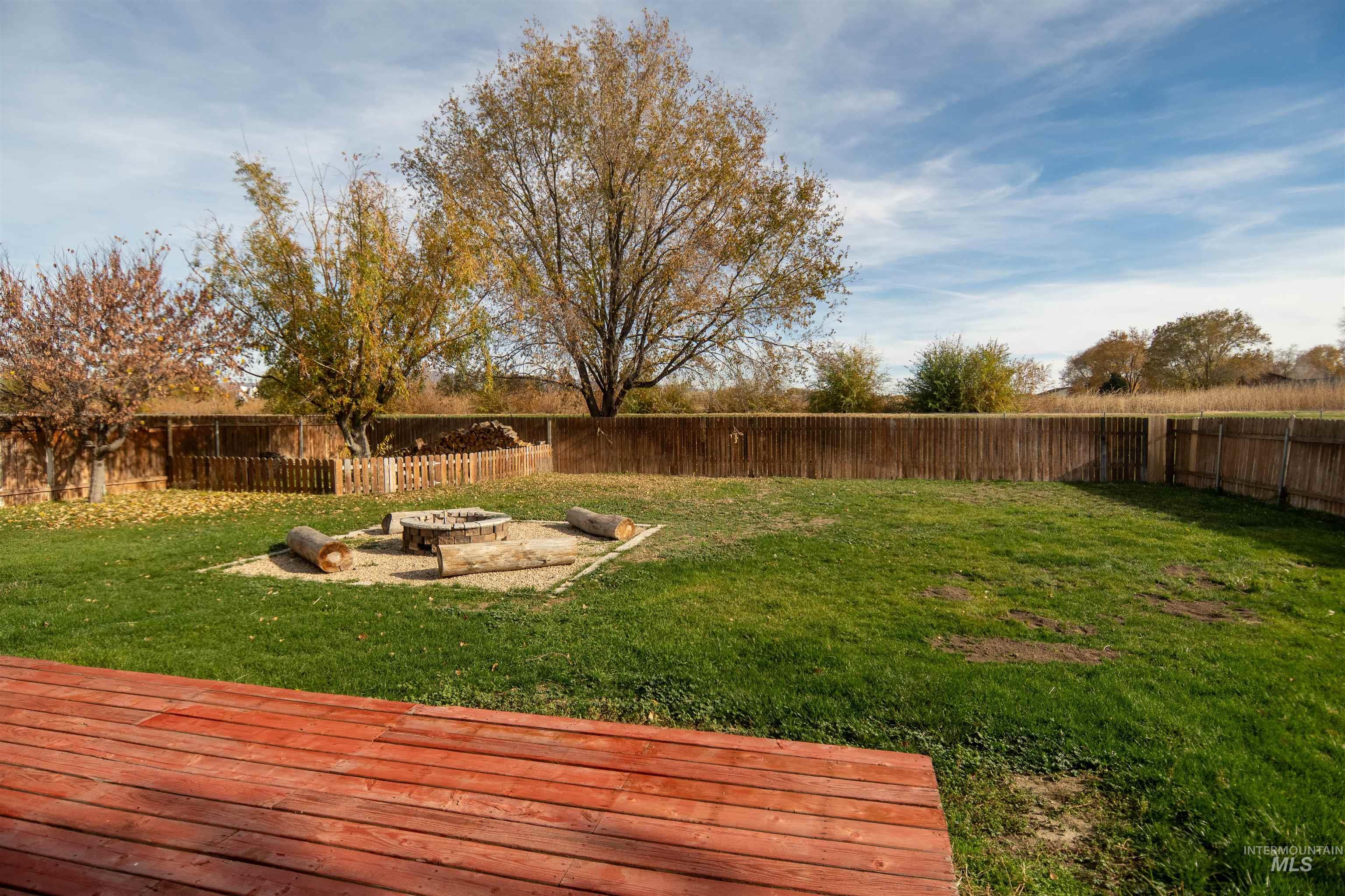 Fenced backyard featuring a fire pit