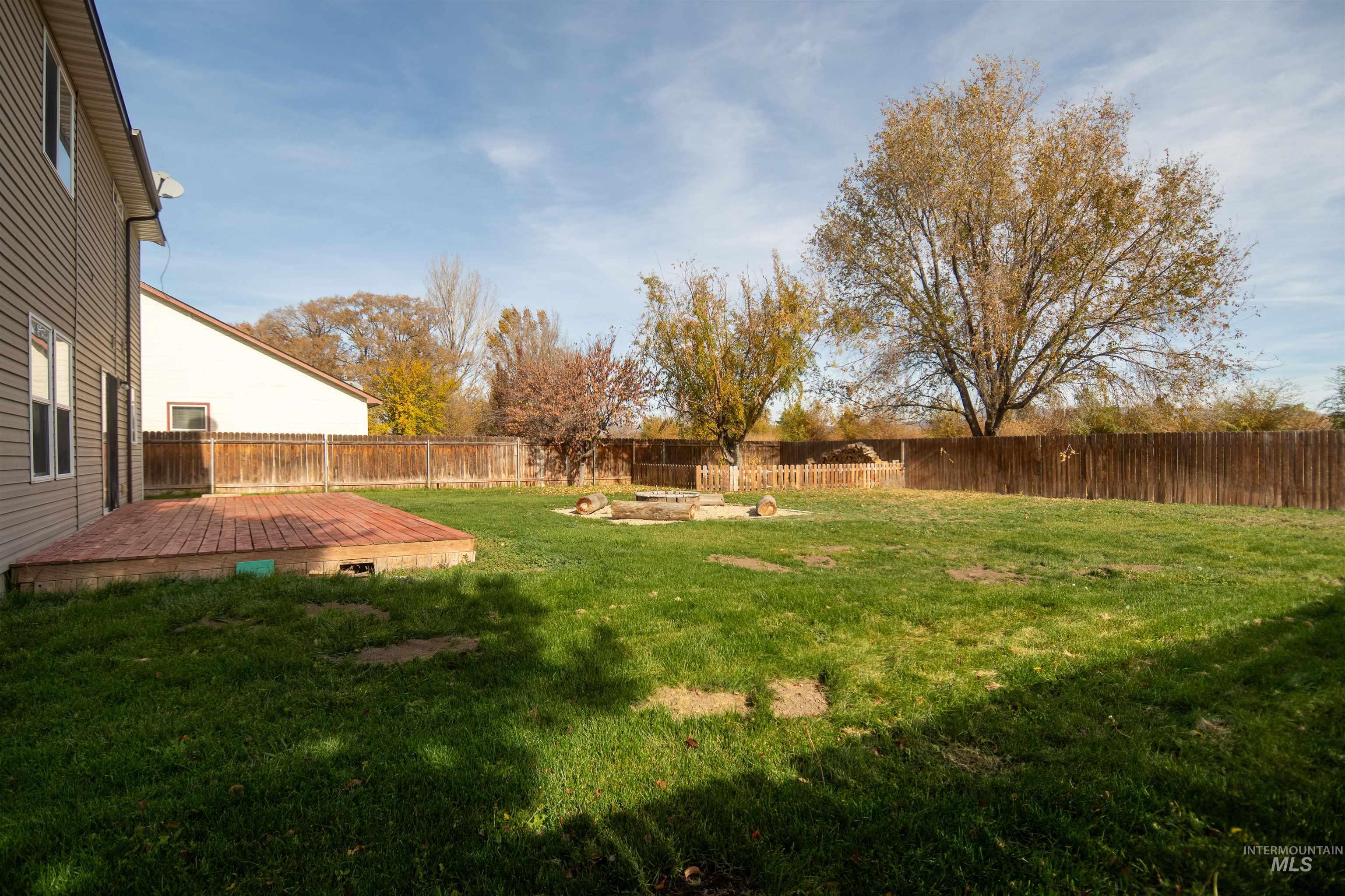 Fenced backyard featuring a deck
