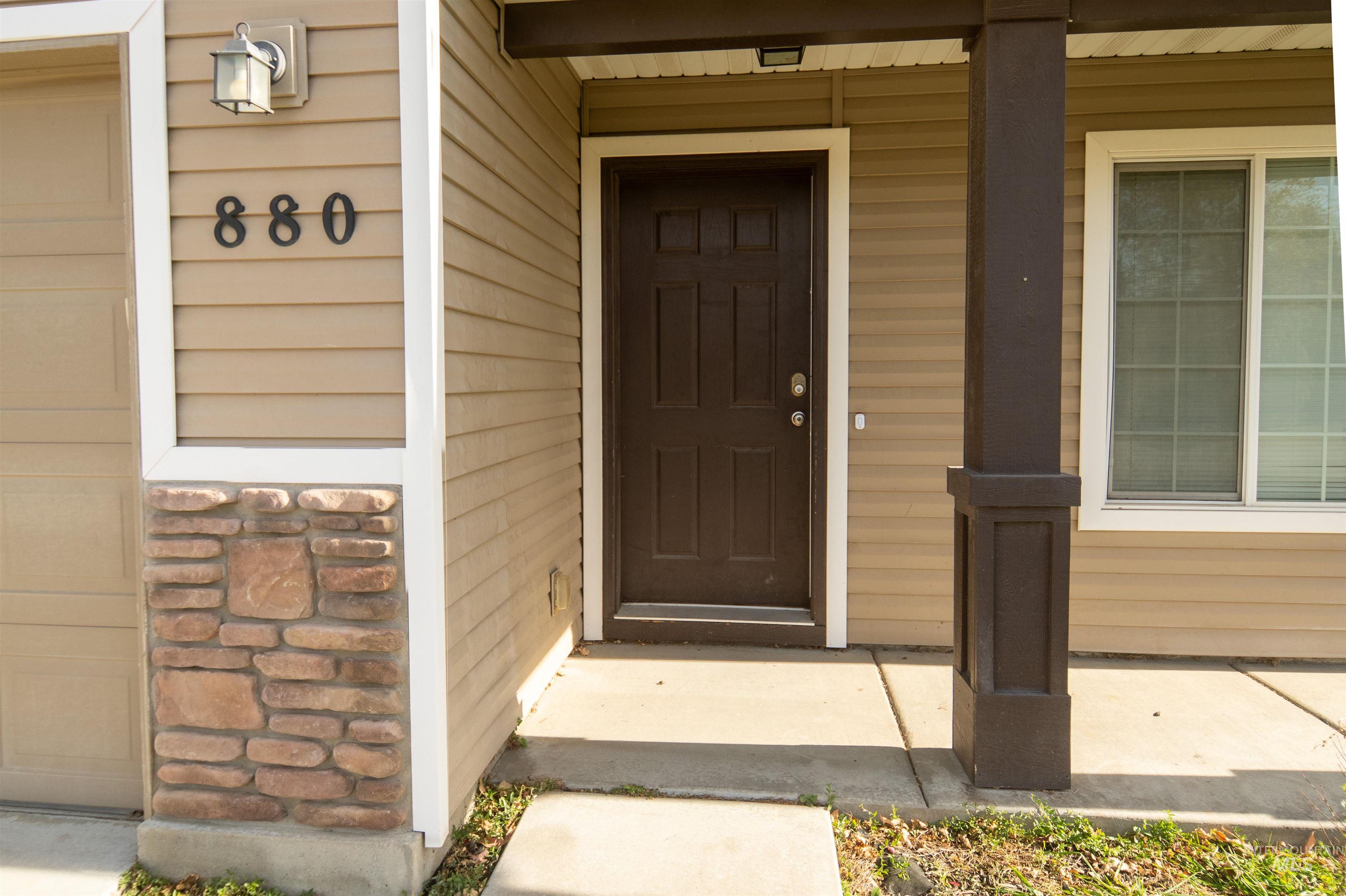 Doorway to property featuring covered porch and stone siding