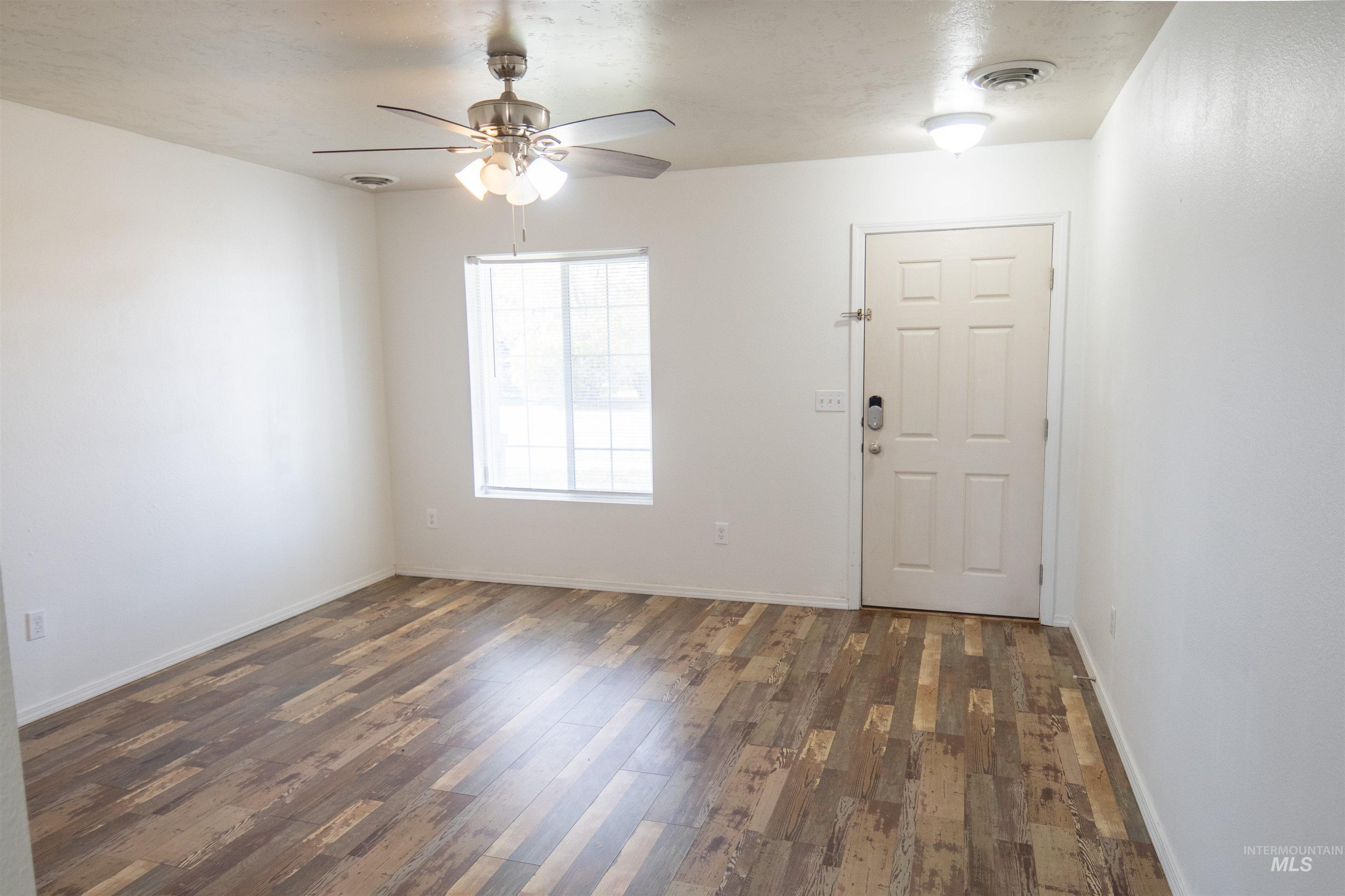 Entrance foyer with dark wood-style flooring and a ceiling fan