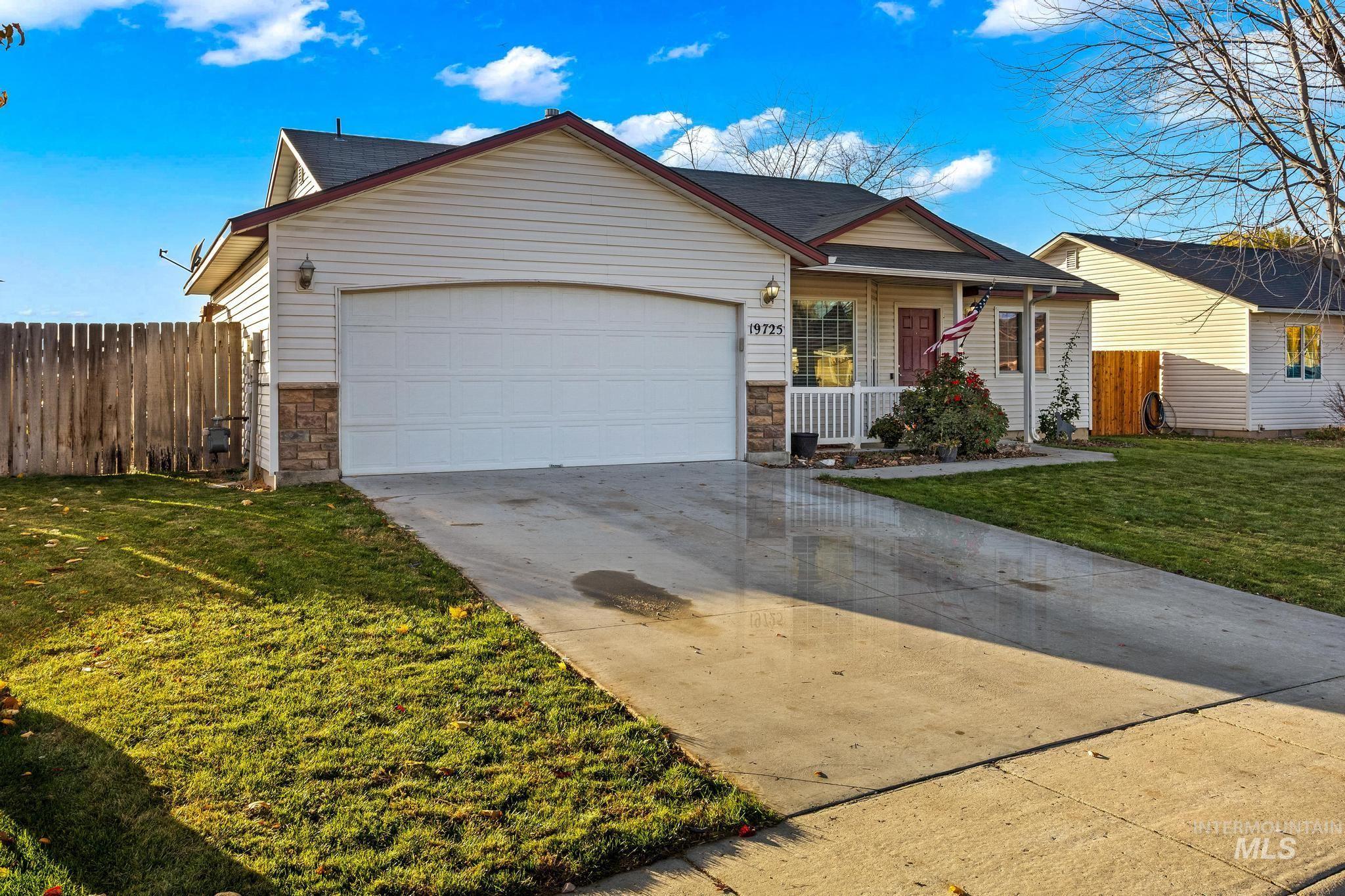 Ranch-style home with stone siding, covered porch, concrete driveway, and an attached garage