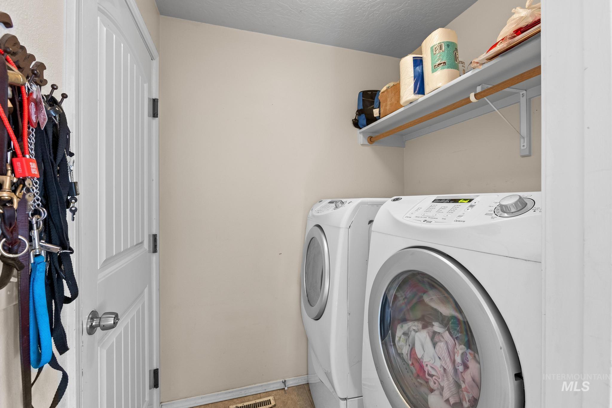 Washroom featuring washer and dryer and a textured ceiling