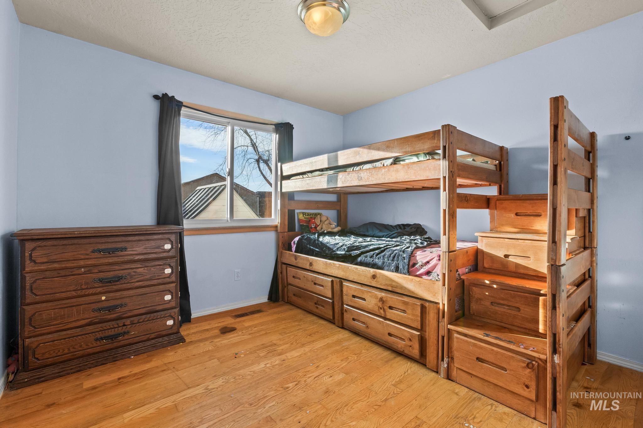 Bedroom featuring light wood-type flooring and a textured ceiling