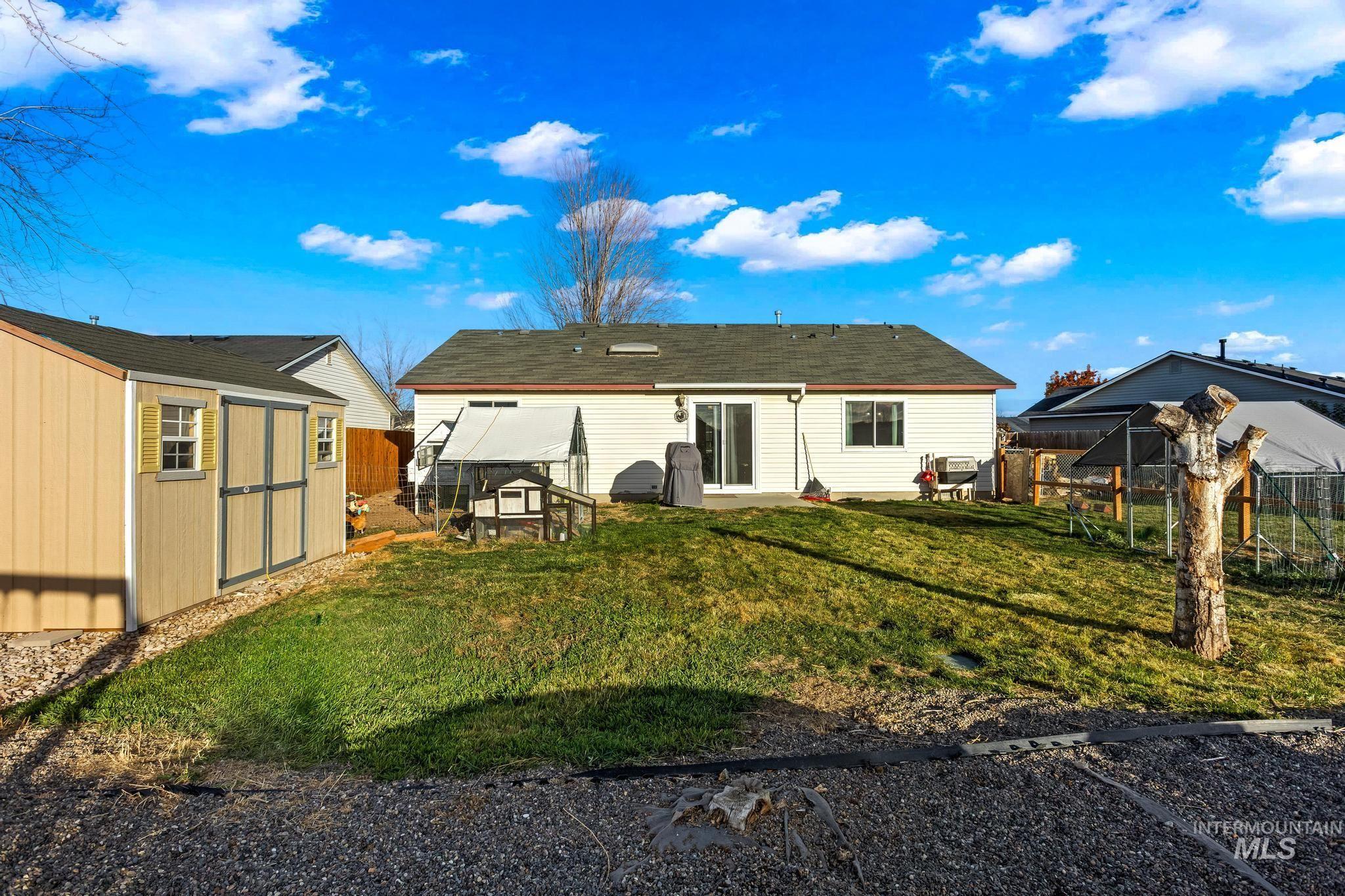 Back of property with a storage shed, a fenced backyard, and exterior structure