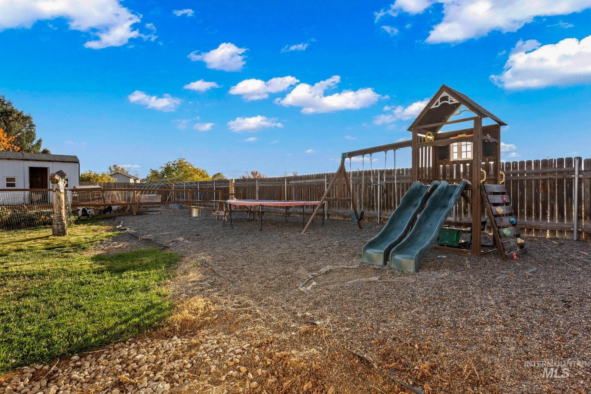 View of playground featuring a fenced backyard and a trampoline