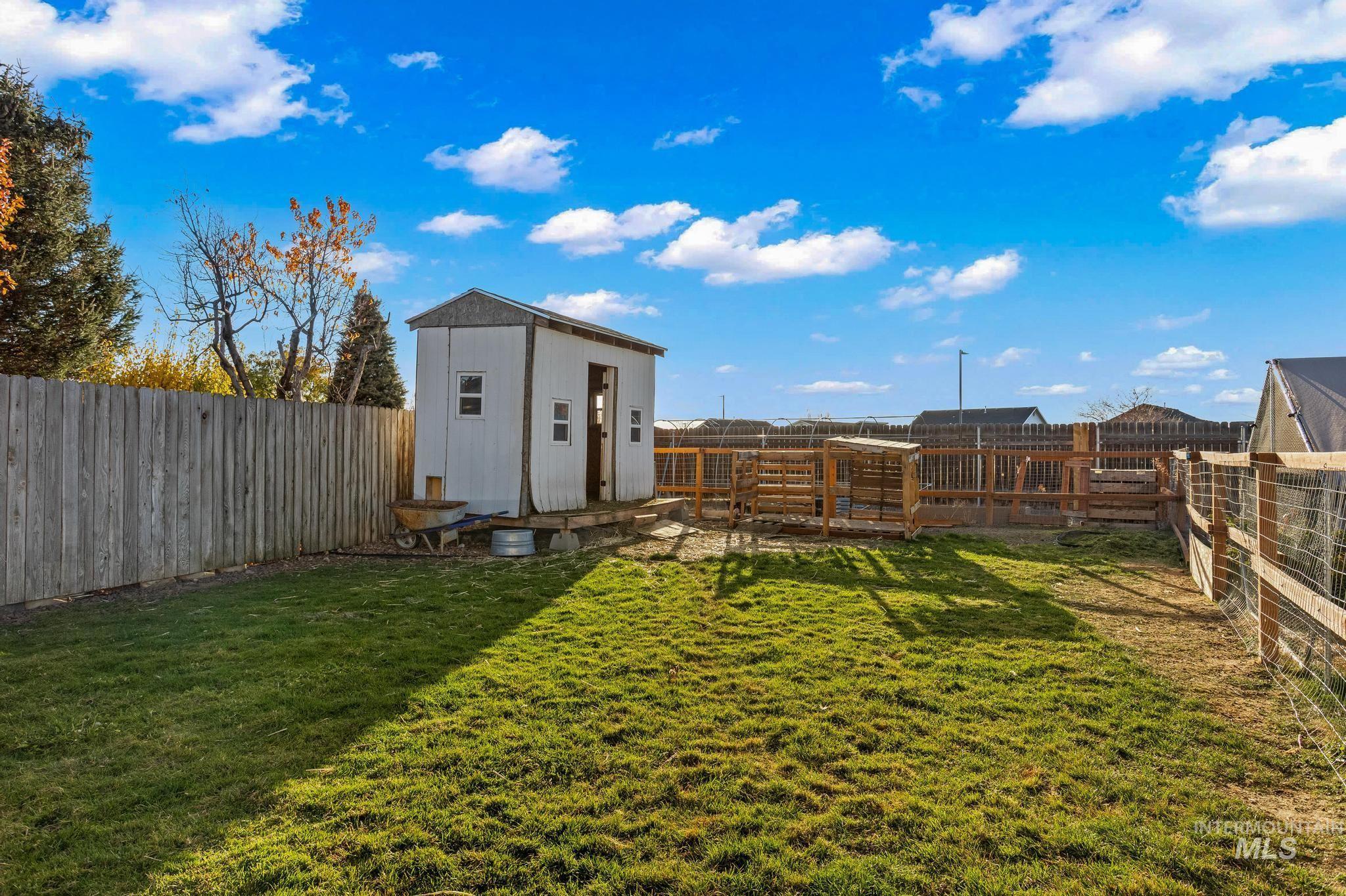 Fenced backyard featuring a storage shed