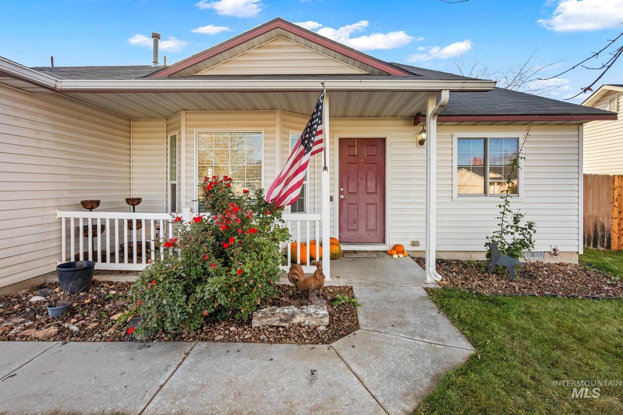 Doorway to property featuring covered porch and a shingled roof
