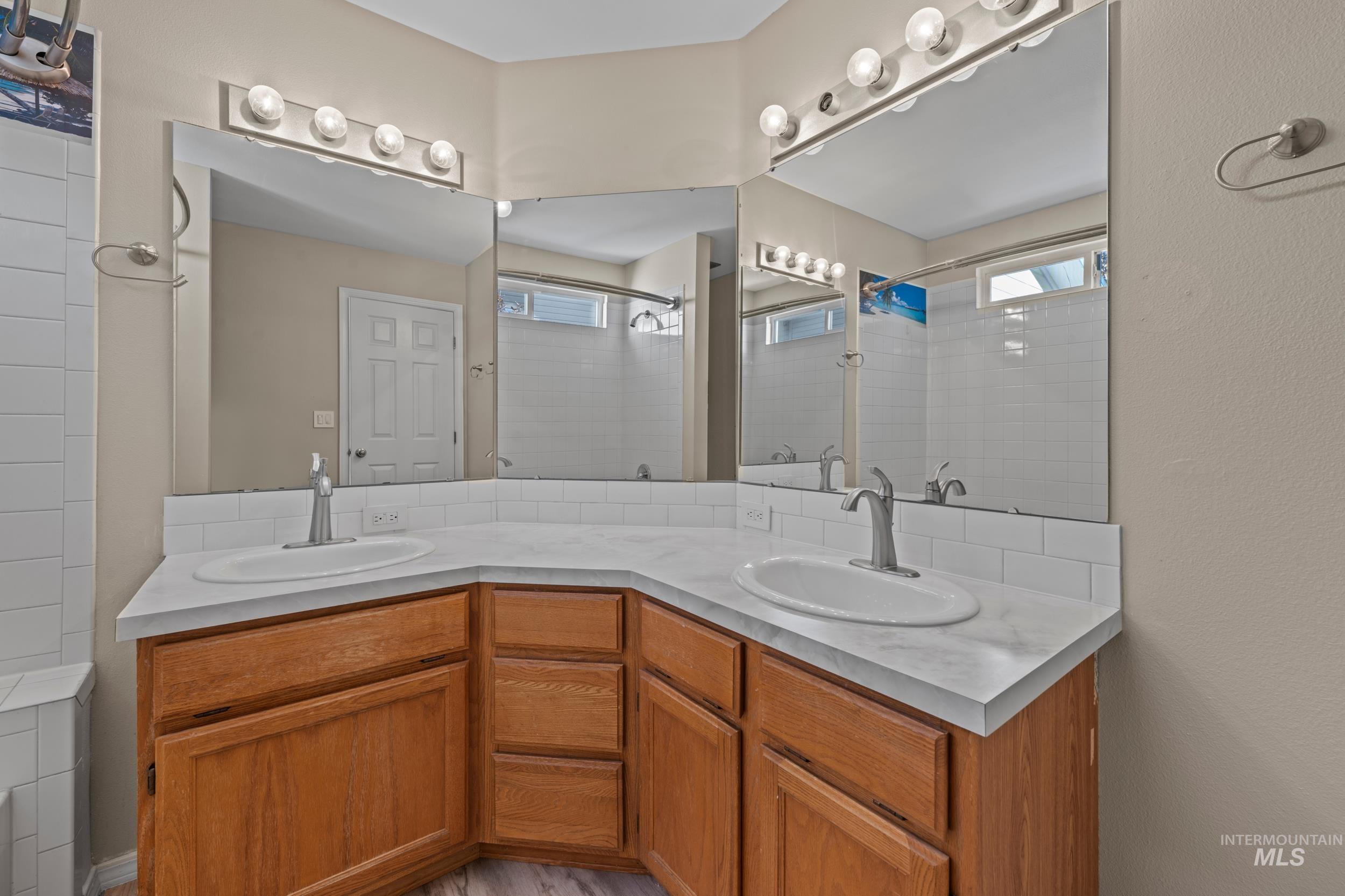 Bathroom with double vanity and tiled shower