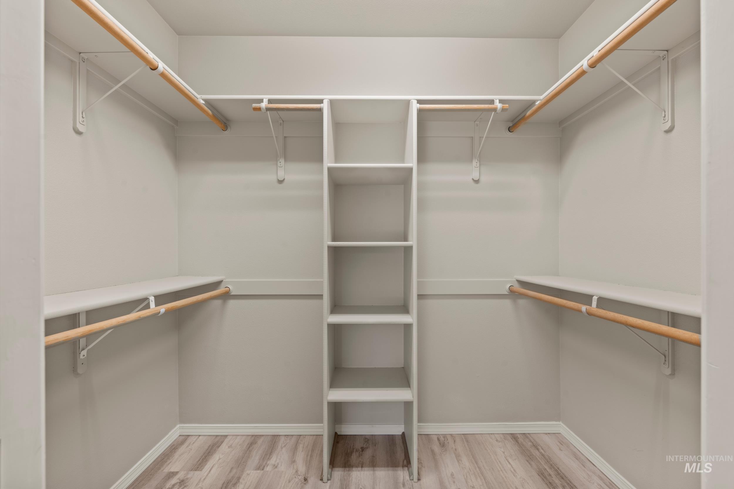 Walk in closet with light wood-type flooring