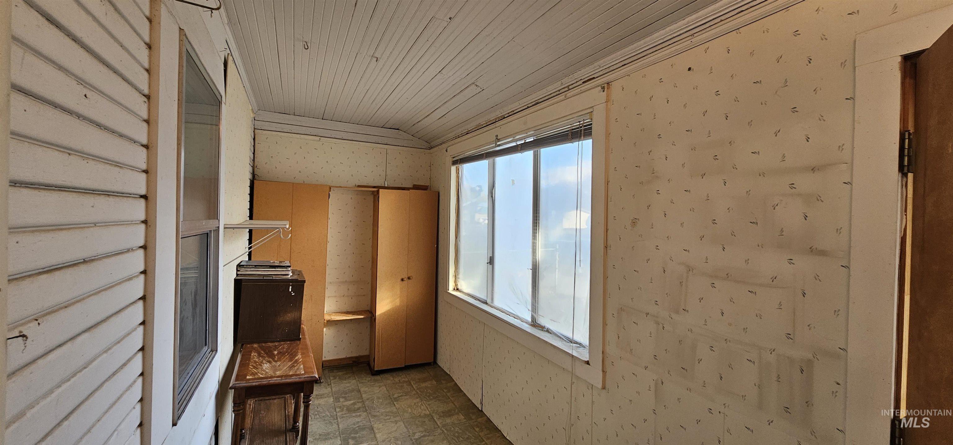 Interior space featuring wallpapered walls and vaulted ceiling