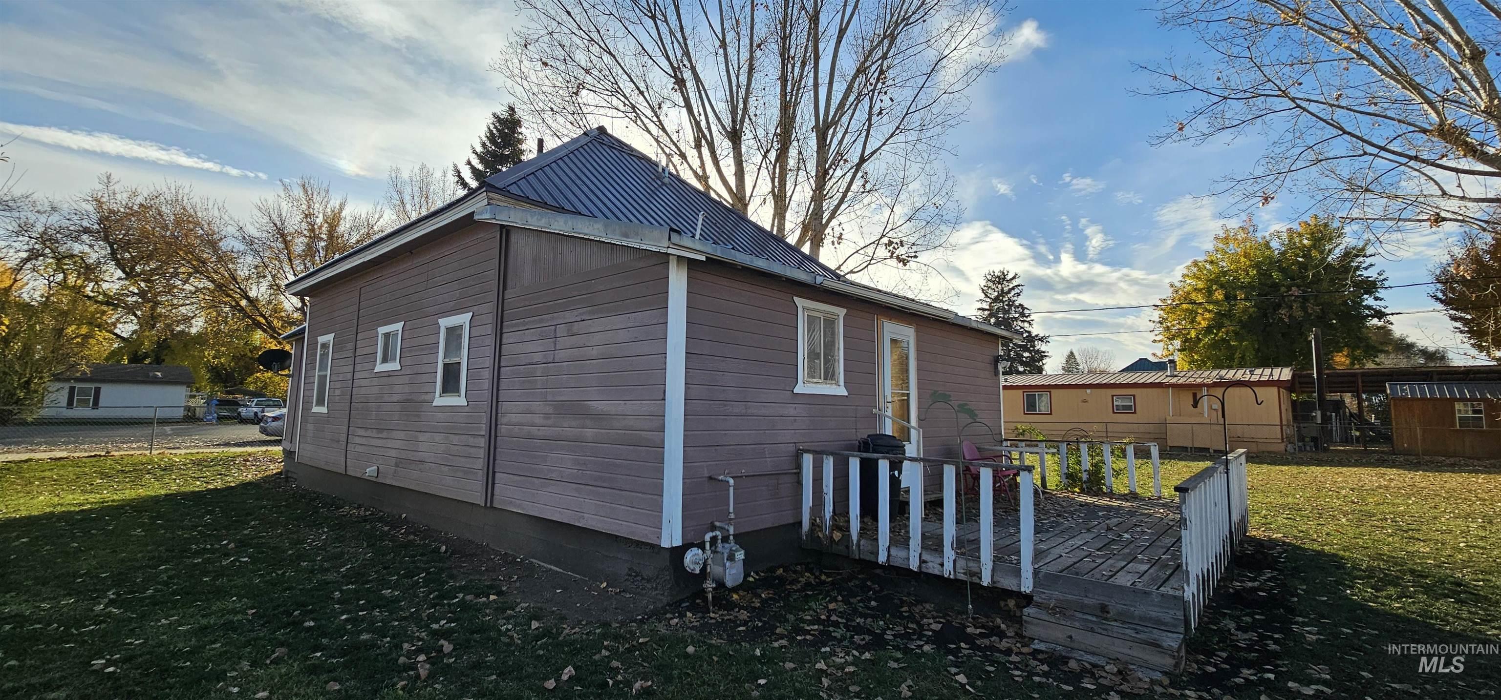 View of property exterior with a deck and a metal roof