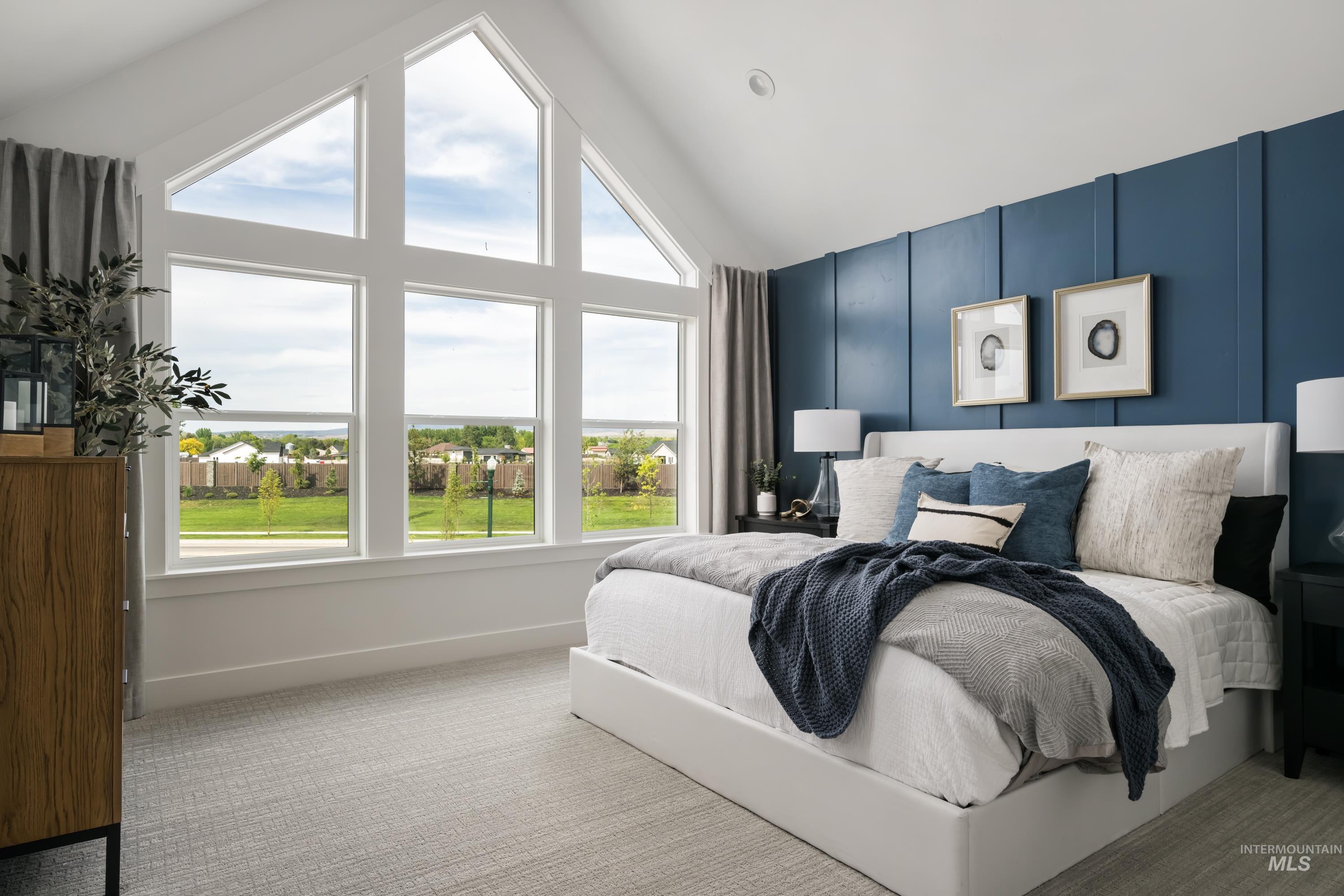Carpeted bedroom featuring baseboards and high vaulted ceiling